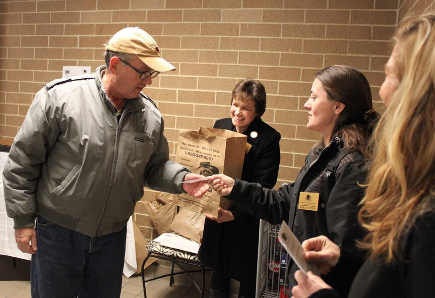 Stephanie Coombs hands a commissary patron a thank you slip after he handed a food donation to Caroline Joyce during the Fisher House for Families of the Fallen food drive Jan. 29, 2011 at the Defense Commissary Agency at Dover Air Force Base, Del. Patrons donated more than $4,500 worth of food during the two-day food drive. (U.S. Air Force photo/Christin Michaud)