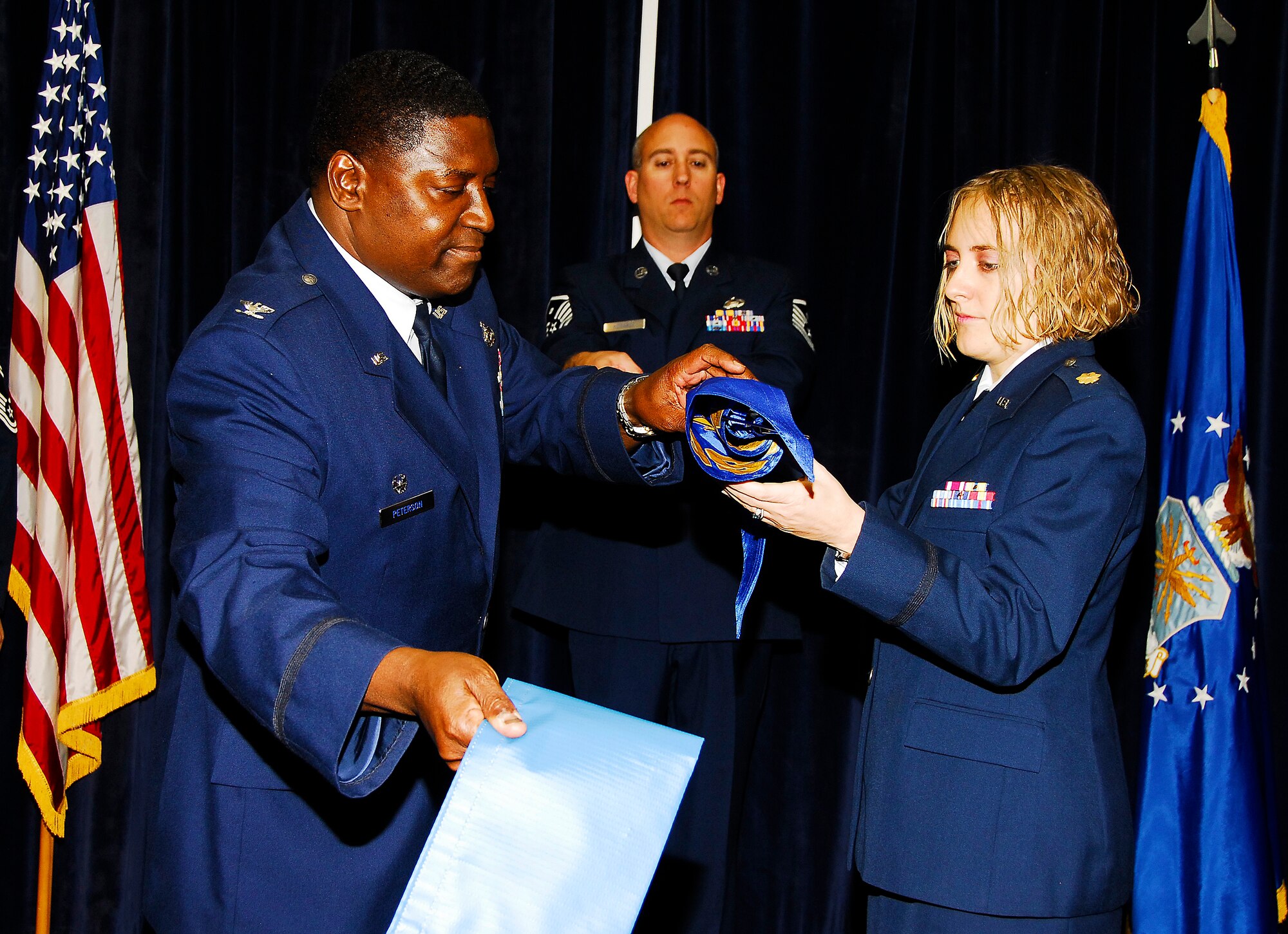 Colonel Pete Peterson, left, new commander of the 908th Mission Support Group, is setting the bar high for his Reservists. Below, one of his first official acts was to oversee the merger of the wings' services and mission support flights to form the new 908th Force Support Squadron,  commanded by Maj. Sara Butler, right.
