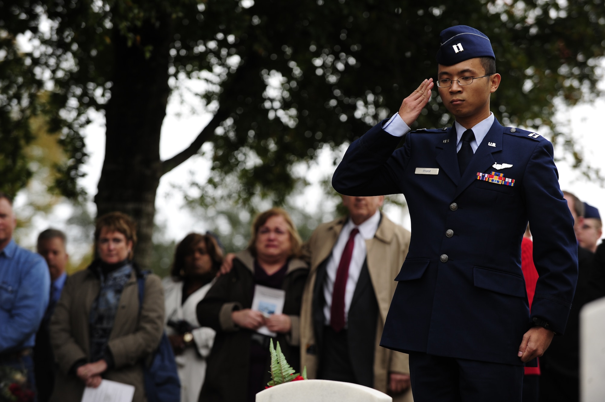U.S. Air Force Capt. Manh Pham, 16th Special Operations Squadron, salutes the gravestone of Tech. Sgt. John L. Oeslchlager during a wreath-laying ceremony, Jan. 31, 2011, at the Barrancas National Cemetery, Pensacola Naval Air Station, Fla. The ceremony marked the 20th anniversary of when 14 Airmen lost their lives when Spirit 03, an AC-130H Spectre gunship, was shot down by enemy fire in support of Operation Desert Storm Jan. 31, 1991. (U.S. Air Force photo by Staff Sgt. Julianne M. Showalter/Released)