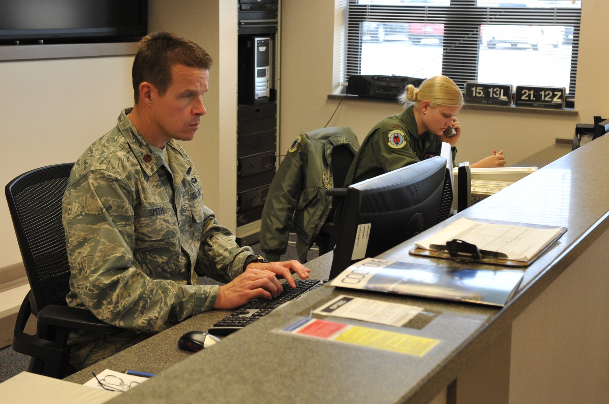 (Left) Maj. David Smith, a 62nd Airlift Squadron operations supervisor, staffs the operations desk with (right) 2nd Lt. Tiffany Szumila, a 62nd AS student navigator, Jan. 25, 2011, at Little Rock Air Force Base, Ark. Operations desk personnel are the focal point for air crews in the day-to-day operations for the 62nd AS. (U.S. Air Force photo by Airman 1st Class Rusty Frank)