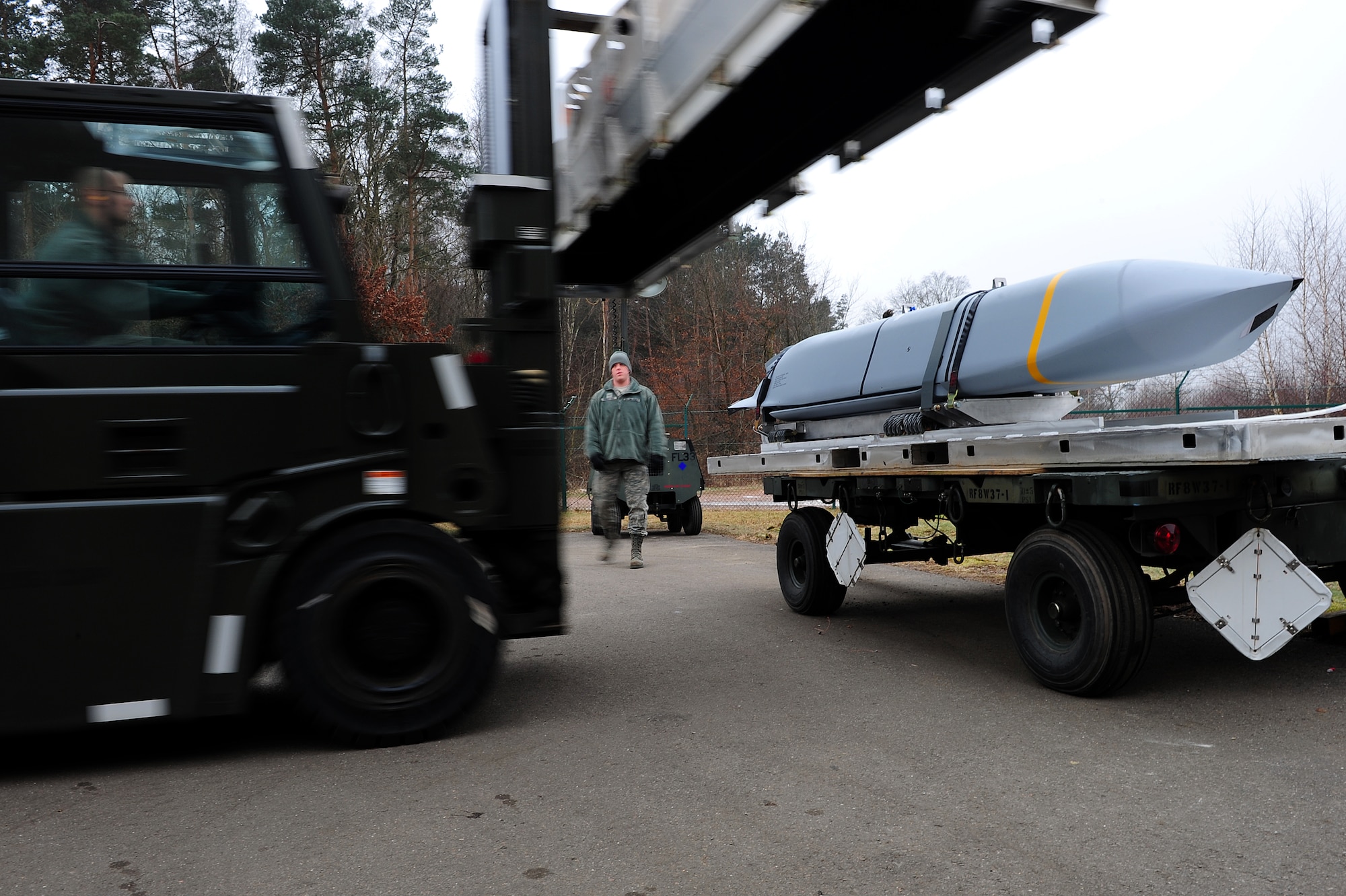 U.S. Air Force Airmen from the 86th Munitions Squadron get in position to secure a joint air-to-surface standoff missile, Ramstein Air Base, Germany, Feb. 1, 2011. The 2,000 pound, semi-stealth, long range weapon requires various maintenance and test operations to ensure its efficiency. (U.S. Air Force photo by Airman 1st Class Brea Miller)