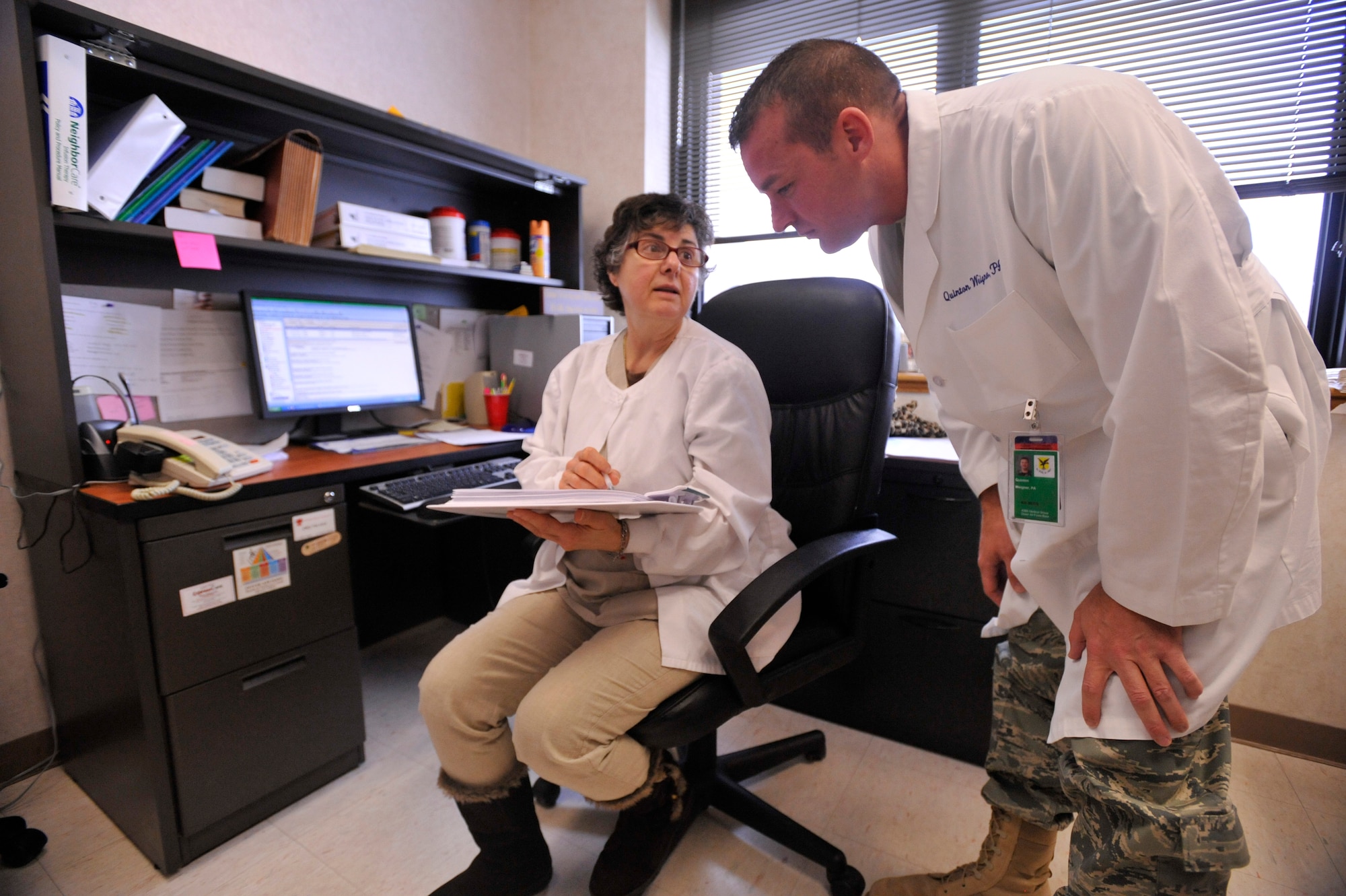 Captain Weigner gets feedback on a patient from Registered Nurse JoAnne Richardson.

