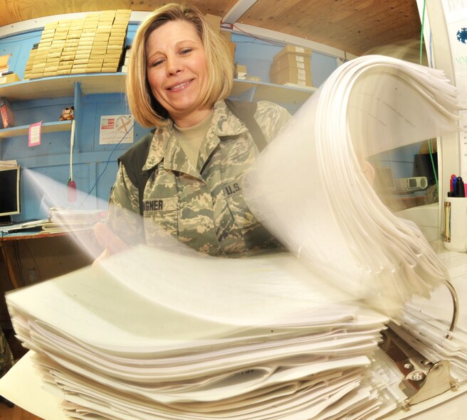 Master Sgt. Apryl Wagner, 467th Casualty Liaison Team non-commissioned officer in charge, flips through a CLT continuity binder Jan. 26, 2011, on Contingency Operating Base Speicher, Iraq. (U.S. Air Force photo by Senior Airman Andrew Lee/Released)