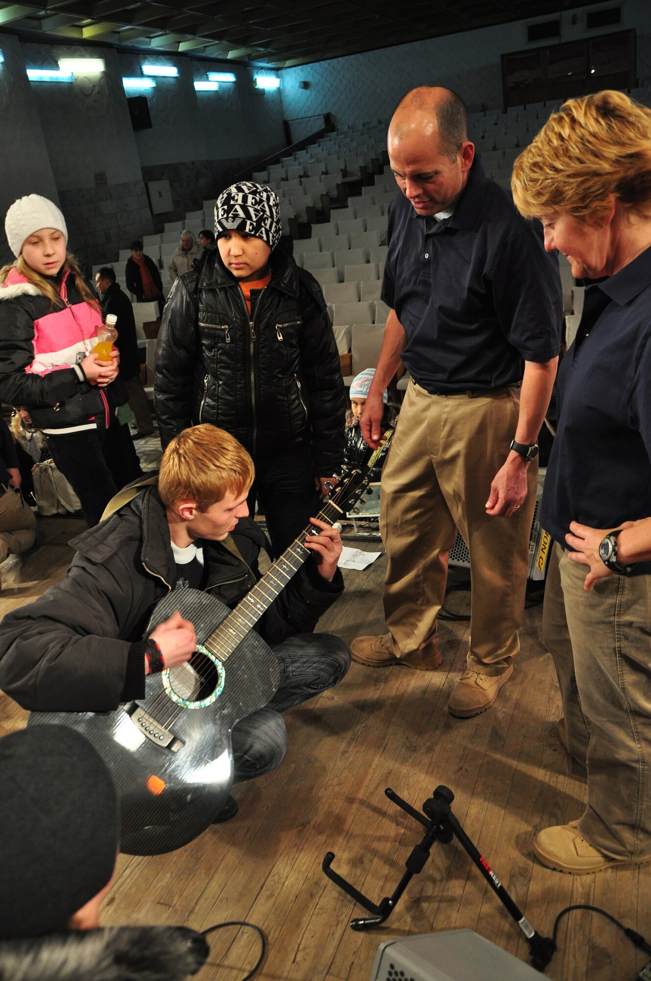 Master Sgt. Jerry Kelley and Tech. Sgt. Christi McGowan, both with the U.S. Air Forces Central band "Starlifter," listen apperciatively to a local student play guitar after a concert they performed at the "Alyi Parus" House of Culture, Kant, Kyrgyzstan, Jan. 31. Starlifter, based out of Scott Air Force Base, Ill., is currently deployed as the U.S. Air Forces Central Expeditionary Band. These dynamic musicians travel throughout the CENTAF Area of Responsibility promoting troop morale, diplomacy and outreach to host nation communities. (U.S. Air Force photo/ Master Sgt. Daniel H. Nathaniel III) 