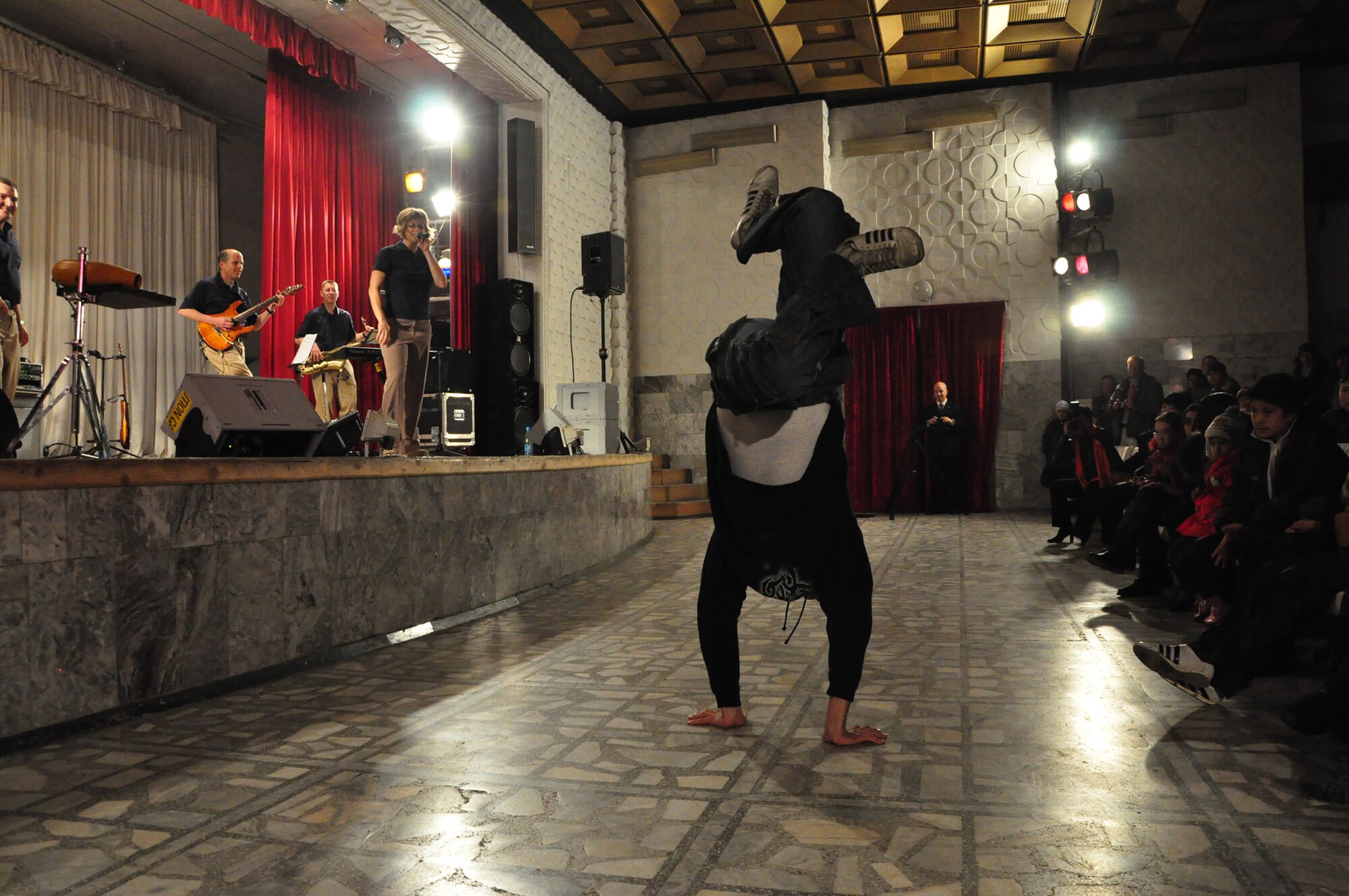 A local Kyrgyz student is inspired to breakdance during a U.S. Air Forces Central band "Starlifter" concert at the "Alyi Parus" House of Culture, Kant, Kyrgyzstan, Jan. 31. Starlifter, based out of Scott Air Force Base, Ill., is currently deployed as the U.S. Air Forces Central Expeditionary Band. These dynamic musicians travel throughout the CENTAF Area of Responsibility promoting troop morale, diplomacy and outreach to host nation communities. (U.S. Air Force photo/ Master Sgt. Daniel H. Nathaniel III) 