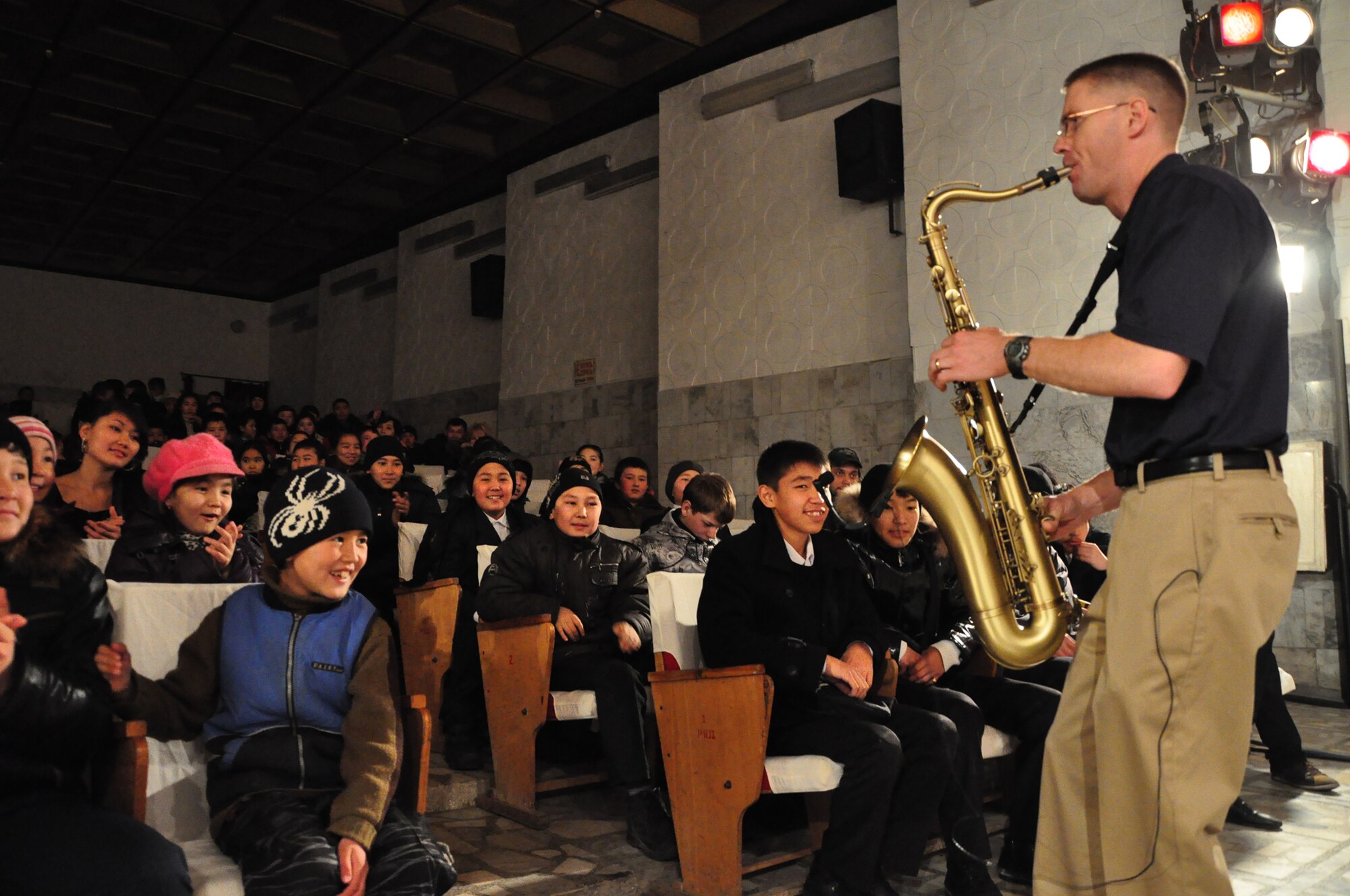 Tech. Sgt. Dwight Wiest jazzes the crowd with a saxophone solo during a U.S. Air Forces Central band "Starlifter" concert at the "Alyi Parus" House of Culture, Kant, Kyrgyzstan, Jan. 31. Starlifter, based out of Scott Air Force Base, Ill., is currently deployed as the U.S. Air Forces Central Expeditionary Band. These dynamic musicians travel throughout the CENTAF Area of Responsibility promoting troop morale, diplomacy and outreach to host nation communities. (U.S. Air Force photo/ Master Sgt. Daniel H. Nathaniel III) 