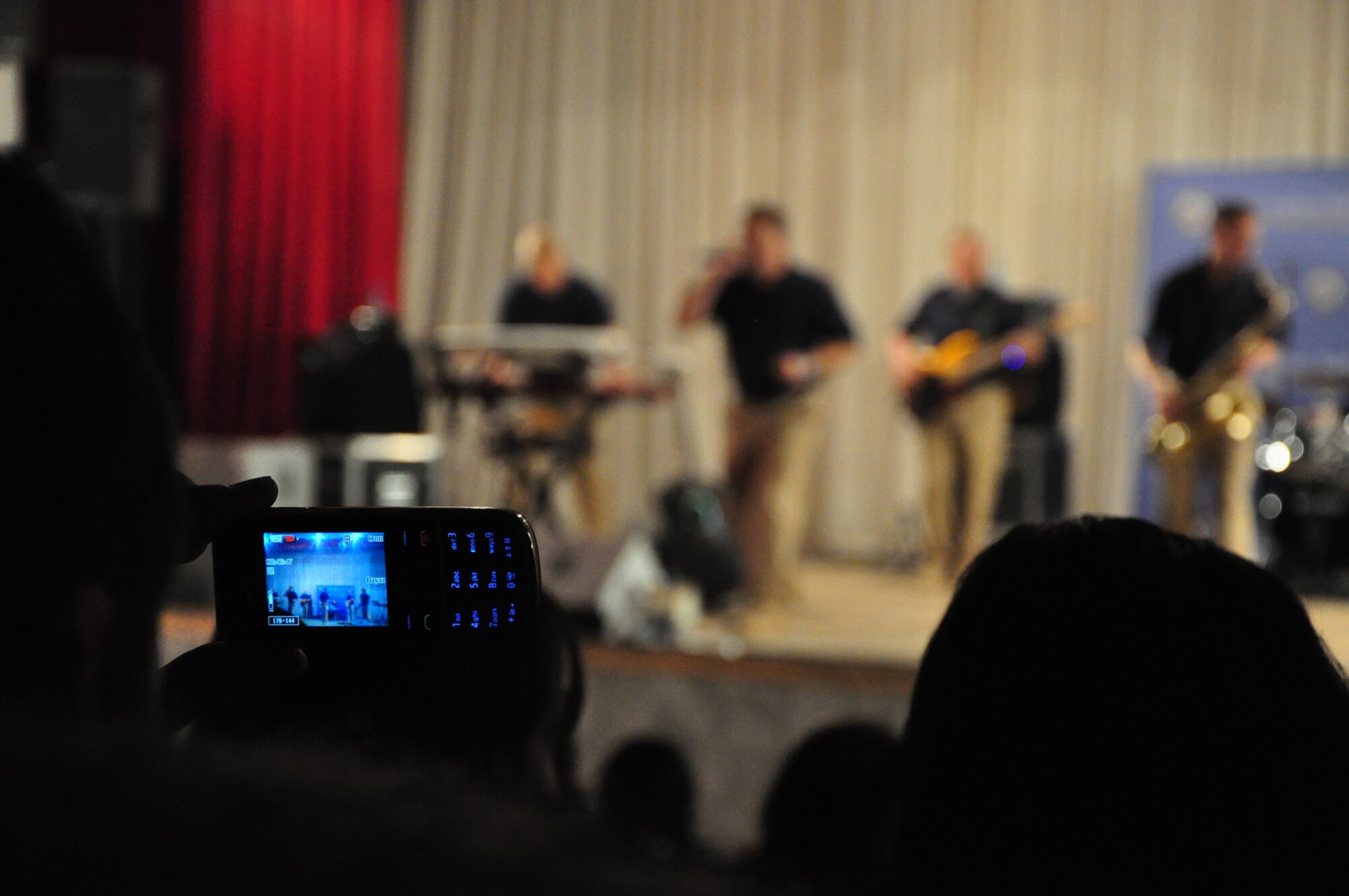 A local Kyrgyz student records the U.S. Air Forces Central band "Starlifter" with a mobile phone during a concert at the "Alyi Parus" House of Culture, Kant, Kyrgyzstan, Jan. 31. Starlifter, based out of Scott Air Force Base, Ill., is currently deployed as the U.S. Air Forces Central Expeditionary Band. These dynamic musicians travel throughout the CENTAF Area of Responsibility promoting troop morale, diplomacy and outreach to host nation communities. (U.S. Air Force photo/ Master Sgt. Daniel H. Nathaniel III) 