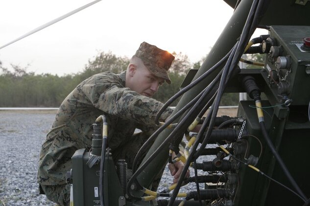 Lance Cpl. Keith Markle, a Stockton, N.J., native and satellite communications operator with Combat Logistics Regiment 3, 3rd Marine Logistics Group, III Marine Expeditionary Force, inspects satellite connection cables here during Exercise Cobra Gold 2011 Feb. 1, 2011. Cobra Gold is design...ed to provide participating nations the opportunity to strengthen bonds between militaries. (Official U.S. Marine Corps photo by Lance Cpl. Kris B. Daberkoe /Released)