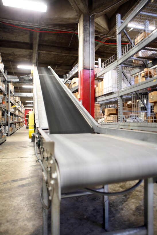 A conveyer belt system hangs from the ceiling inside one of the warehouses belonging to the Supply Management Unit, 2nd Supply Battalion, 2nd Marine Logistics Group, aboard Camp Lejeune, N.C., Feb. 2, 2011. Though the system fell out of use nearly a decade ago, the tempo of today’s society of supply and demand prompted the unit’s leadership to have the conveyer restored. (U.S. Marine Corps photo by Pfc. Franklin E. Mercado)