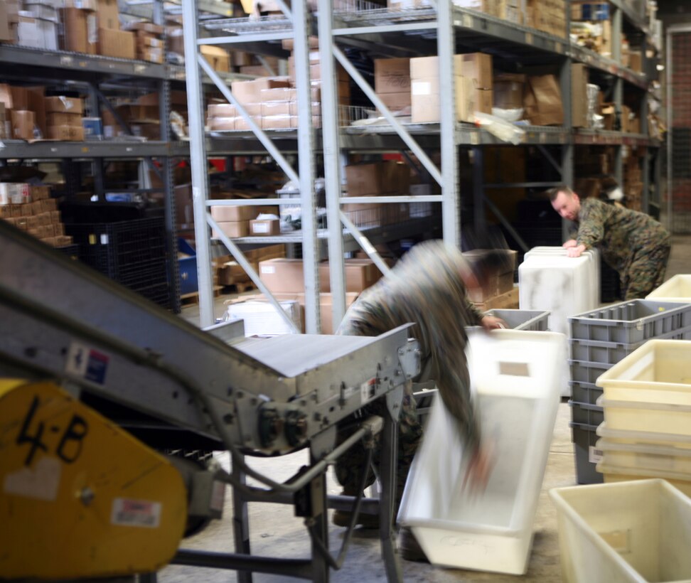 Marines with Supply Management Unit, 2nd Supply Battalion, 2nd Marine Logistics Group, use a conveyer belt system to move boxes to the opposite side of their warehouse aboard Camp Lejeune, N.C., Feb. 2, 2011. Though the system fell out of use nearly a decade ago, the tempo of today’s society of supply and demand prompted the unit’s leadership to have the conveyer restored. (U.S. Marine Corps photo by Pfc. Franklin E. Mercado)