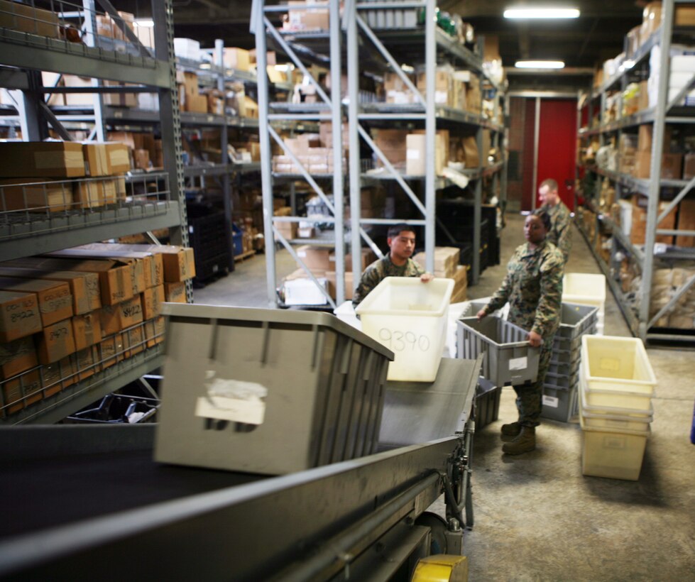Marines with Supply Management Unit, 2nd Supply Battalion, 2nd Marine Logistics Group, use a conveyer belt system to move boxes to the opposite side of their warehouse aboard Camp Lejeune, N.C., Feb. 2, 2011. Though the system fell out of use nearly a decade ago, the tempo of today’s society of supply and demand prompted the unit’s leadership to have the conveyer restored. (U.S. Marine Corps photo by Pfc. Franklin E. Mercado)