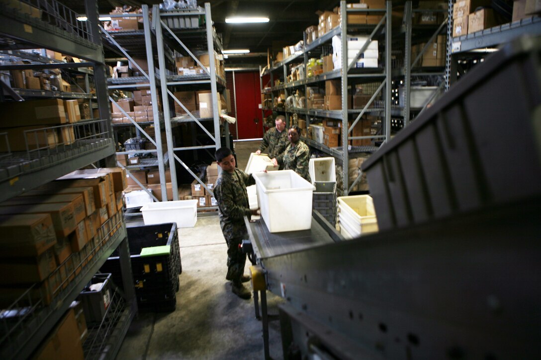 Marines with Supply Management Unit, 2nd Supply Battalion, 2nd Marine Logistics Group, use a conveyer belt system to move boxes to the opposite side of their warehouse aboard Camp Lejeune, N.C., Feb. 2, 2011. Though the system fell out of use nearly a decade ago, the tempo of today’s society of supply and demand prompted the unit’s leadership to have the conveyer restored. (U.S. Marine Corps photo by Pfc. Franklin E. Mercado)