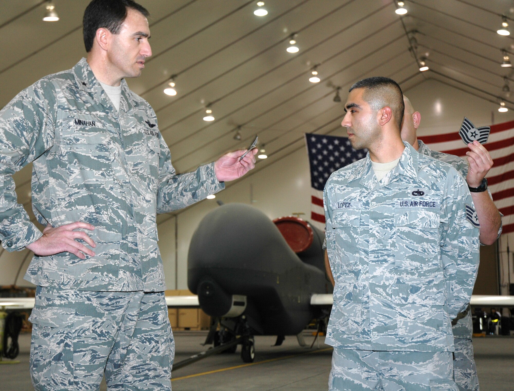 Brig. Gen. Mike Minahan, 380th Air Expeditionary Wing commander, presents a surprised Staff Sgt. Daniel Lopez with technical sergeant stripes during a recent 380th Expeditionary Aircraft Maintenance Squadron formation. Tech. Sgt. Lopez was awarded the promotion through the Air Force's Stripes for Exceptional Performers (STEP) program. (U.S. Air Force photo by Master Sgt. Julie Briden-Garcia)
