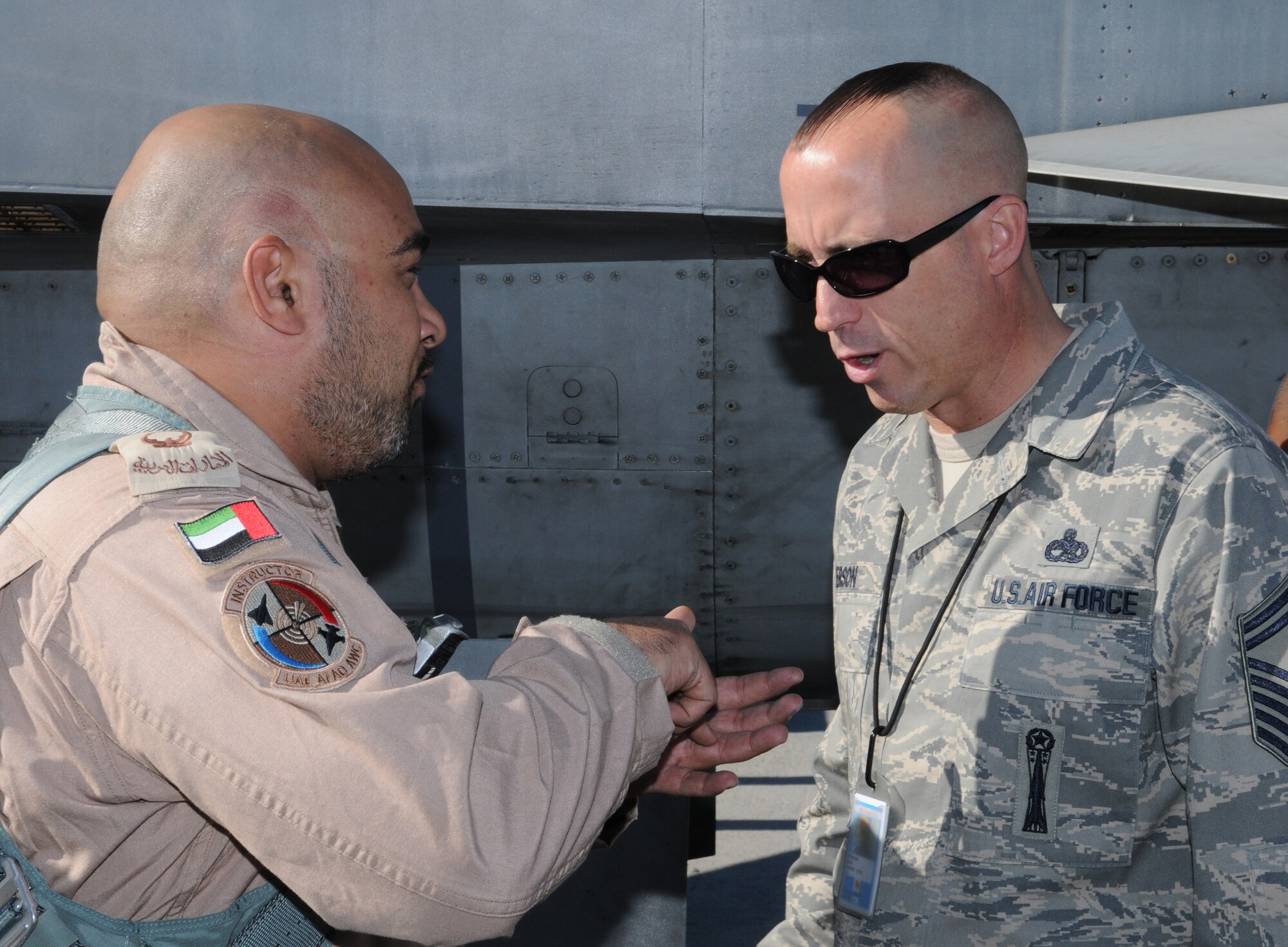 NELLIS AIR FORCE BASE, Nev. -- Maj. Adel Al Menhaly, F-16 Desert Falcon pilot, speaks with Senior Master Sergeant Roy Person, United Arab Emirates Embassy weapons program manager, after returning from a mission during Red Flag 11-2 Jan. 31. The United Arab Emirates air force is participating in a Red Flag exercise to strengthen international relations and training for the second time. (U.S. Air Force photo/Staff Sgt. Benjamin Wilson)