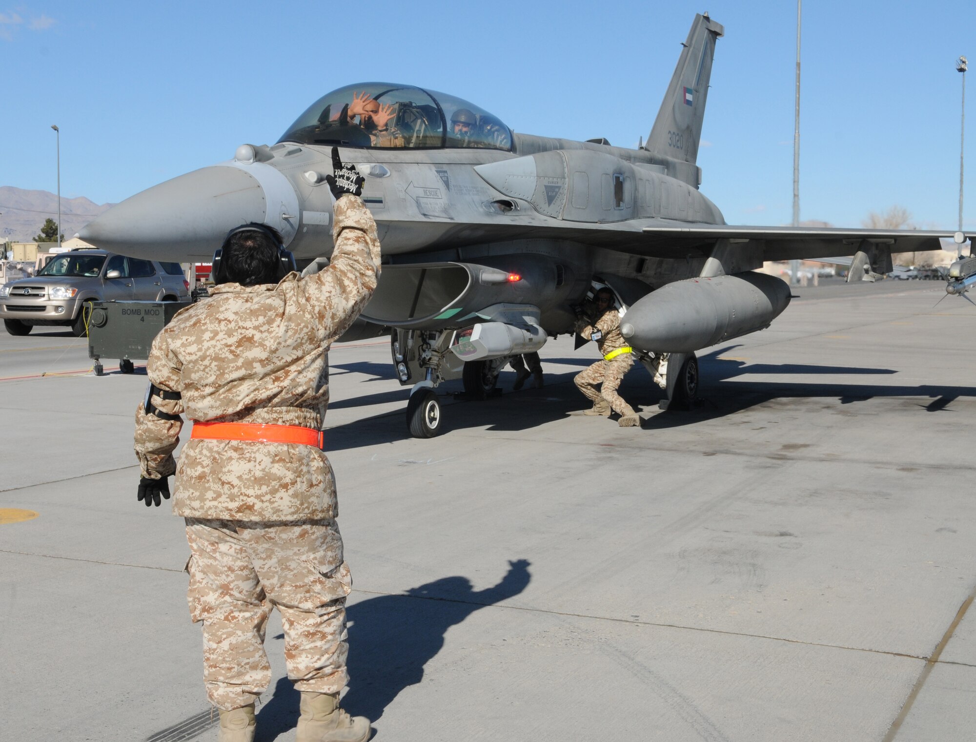 NELLIS AIR FORCE BASE, Nev. -- A maintainer from the United Arab Emirates air force gives hand signals to an F-16 Desert Falcon pilot after a mission during Red Flag 11-2 Jan. 31. The United Arab Emirates air force is participating in a Red Flag exercise to strengthen international relations and training for the second time. (U.S. Air Force photo/Staff Sgt. Benjamin Wilson)
