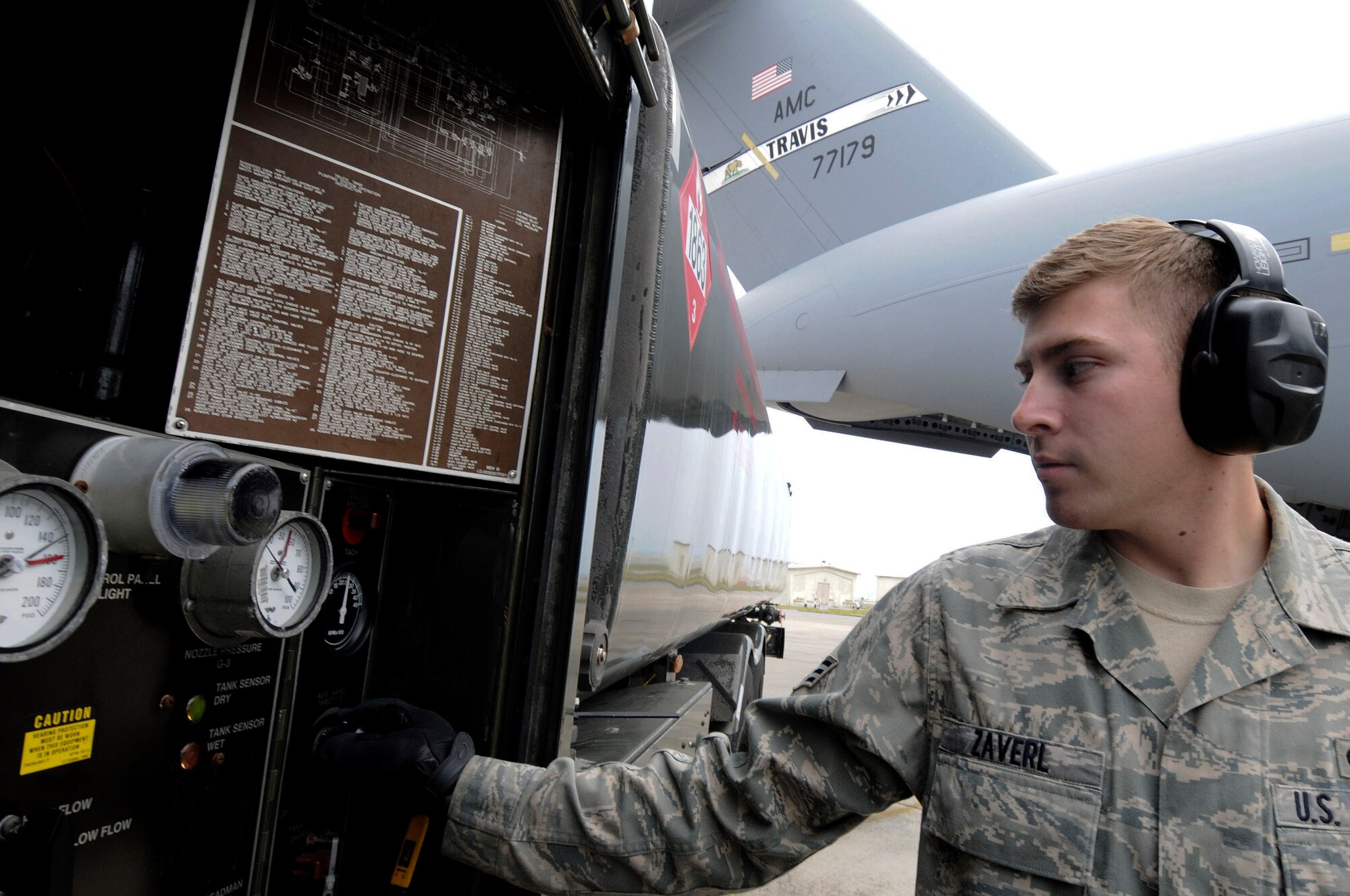 Senior Airman Shawn Zaverl with the 18th Logistics Readiness Squadron controls the amount of fuel loading from an R11 refueling truck to a C-17 Globemaster at Kadena Air Base, Feb 2. The C-17 defueling/refueling procedures were made more efficient as a result of an IDEA program submission. (U.S. Air Force photo/Staff Sgt. Darnell T. Cannady)