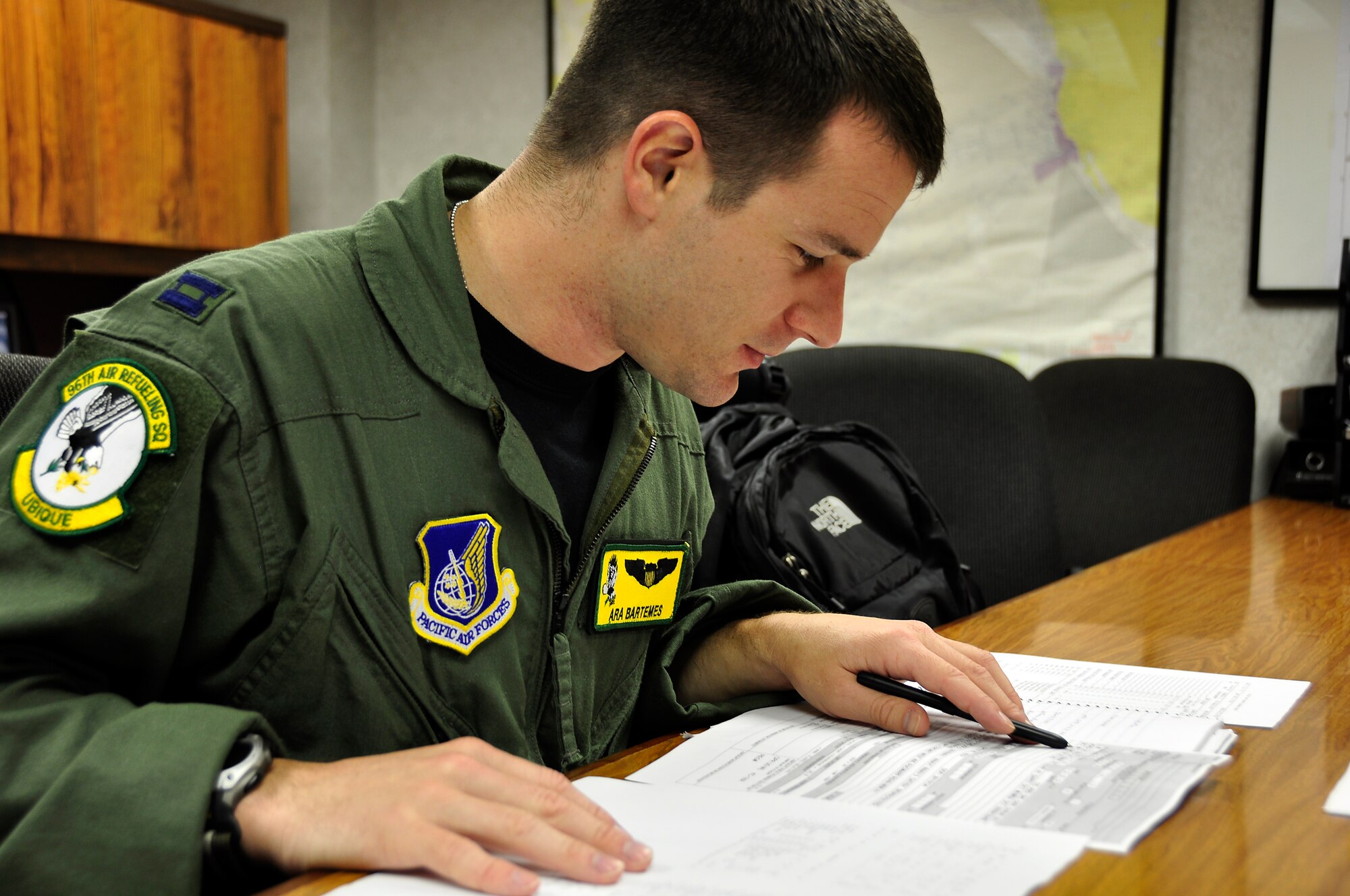 Capt. Ara Bartemes, 96th Air Refueling Squadron KC-135 pilot, goes over mission planning paperwork prior to take-off for their first off-station operational mission to refuel six Marine Corps F/A-18 Prowlers from Iwakuni Air Base, Japan.  The newly operational air refueling squadron plans to be fully operational as of March 1, 2011. (U.S. Air Force photo/Maj. Jeff Paget)
