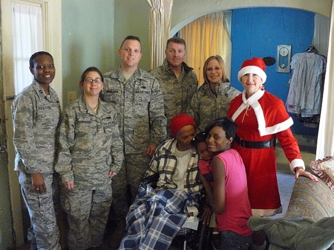 Wingmen of the 908th Logistics Readiness Squadron delivered Christmas presents to a needy local family which had recently left an abusivee situation. Pictured with the family, from left, are  Capt. Tonia Stephens, Staff Sgt. Alicia Livingston, Master Sgt. Darrell Geiselman, Tech. Sgt. Ronnie Warner, Senior Airman Joy Bates and Master Sgt. Vera Berry.
