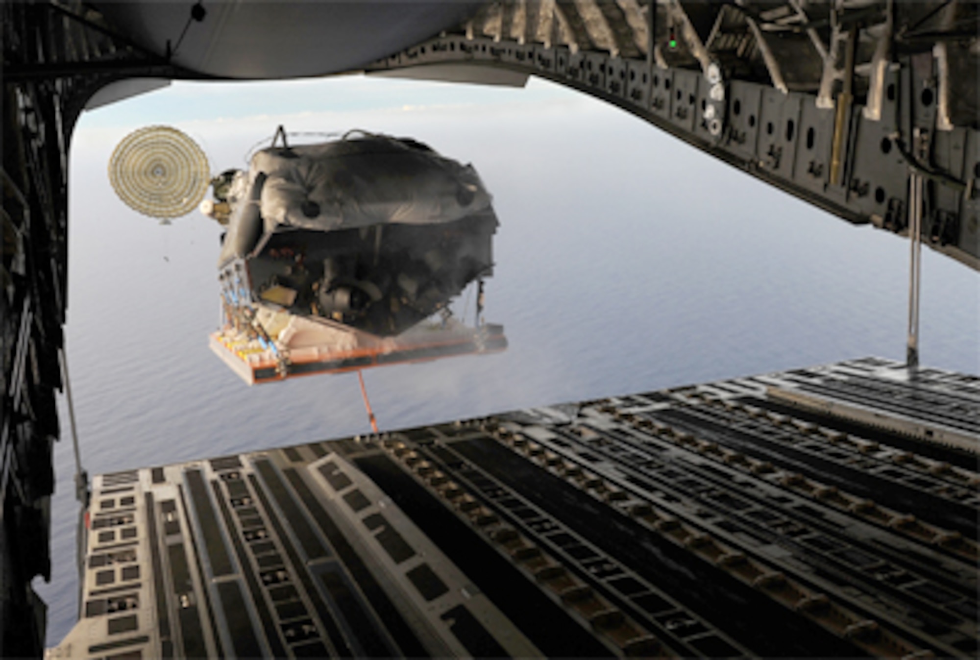The Navy Special Warfare Unit ONE Maritime Craft Aerial Delivery System deploys from the ramp of a C-17 Globemaster III during airdrop operations Jan. 13, 2011 over the Pacific Ocean near Guam. Nine Sailors jumped out of the back of a C-17 after the aerial drop. Airmen from Joint Base Pearl Harbor-Hickam, Hawaii, worked with the Naval unit to deploy the boat off the coast of Guam while merging the capabilities of the U.S. Air Force and the U.S. Navy. (U.S. Air Force photo/Staff Sgt. Mike Meares)