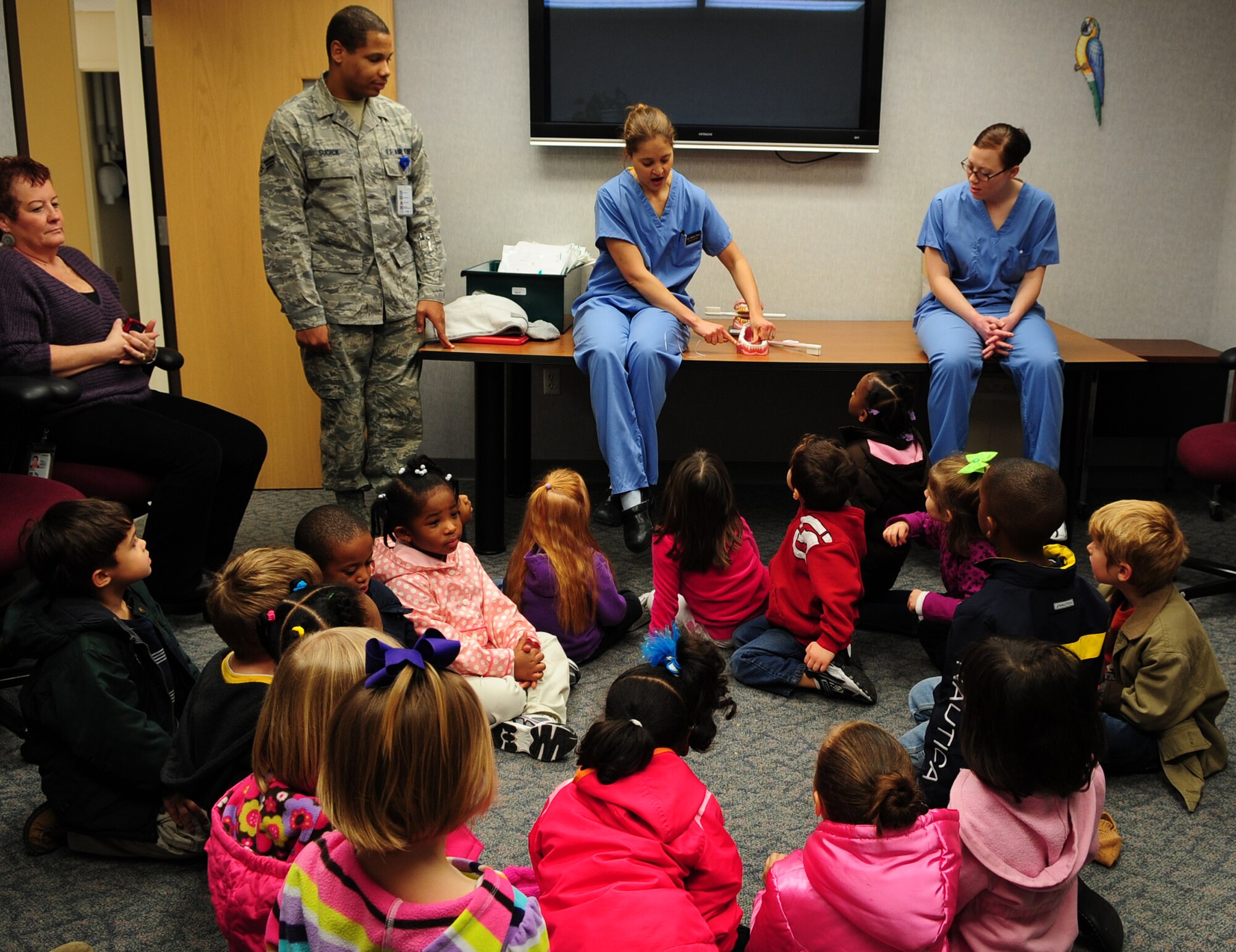 MOODY AIR FORCE BASE, Ga.-- Capt. Meghan Darby, 23rd Aeromedical Dental Squadron general dentist, teaches 4- and- 5-year-olds kids how to properly brush and floss their teeth by using a mouth model Feb. 1. February is Children’s Dental Health Month, so the dental clinic is educating children on proper hygiene, diet and regular dental visits. (U.S. Air Force photo/Senior Airman Stephanie Mancha)(RELEASED)