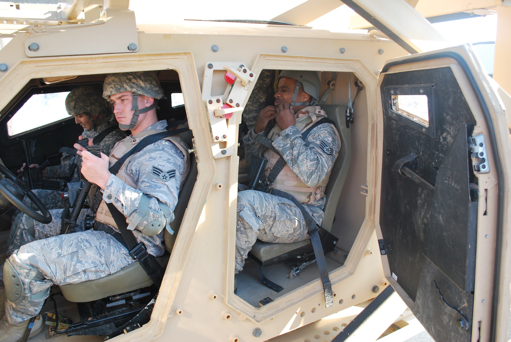 Senior Airman  James Randolph and Staff Sgt. Marlow Dotts pull their safety belts tight as they prepare to roll over in the Mine Resistant Ambush Protected vehicle roll-over egress trainer.  Randolph, assigned to the 28th Contracting Squadron, Ellsworth Air Force Base, S.D., and Dotts, 87th Contracting Squadron, McGuire Air Force Base, N.J., joined 21 other contracting airmen participated in Operation Joint Dawn 2011, a U.S. Army Expeditionary Contracting Command pre-deployment exercise held at Fort Campbell, Ky.  (U.S. Army Photo by Ed Worley)
