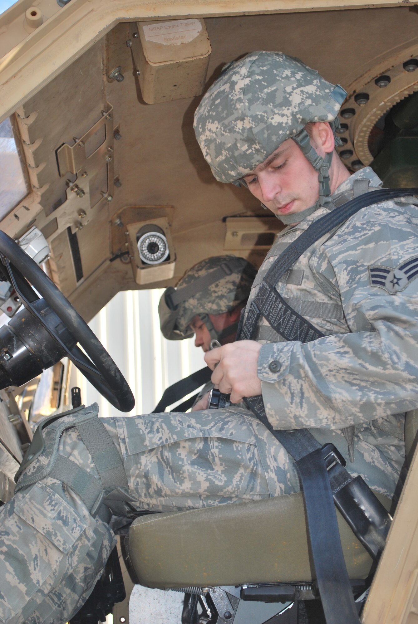 Senior Airman George Halley straps into the Mine Resistant Ambush Protected vehicle roll-over egress trainer.  Halley is assigned to the 18th  Contracting Squadron, Kadena Air Base, Japan.  He and 22 other contracting airmen participated in Operation Joint Dawn 2011, a U.S. Army Expeditionary Contracting Command pre-deployment exercise held at Fort Campbell, Ky.  (U.S. Army Photo by Ed Worley)