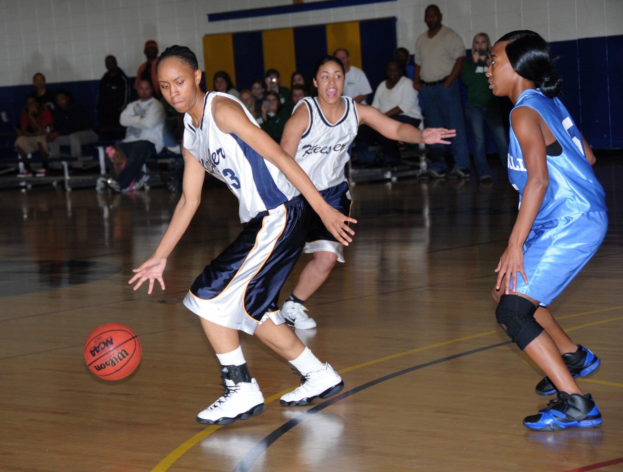 From left, Lady Dragon Veronique Williams works her away around the court with teammate Brittany Austin coming in for backup as Bernadette Crimbley from Tyndall
guards the net. The Lady Dragons claimed a 67-62 win.  (U.S. Air Force photo by Kemberly Groue)