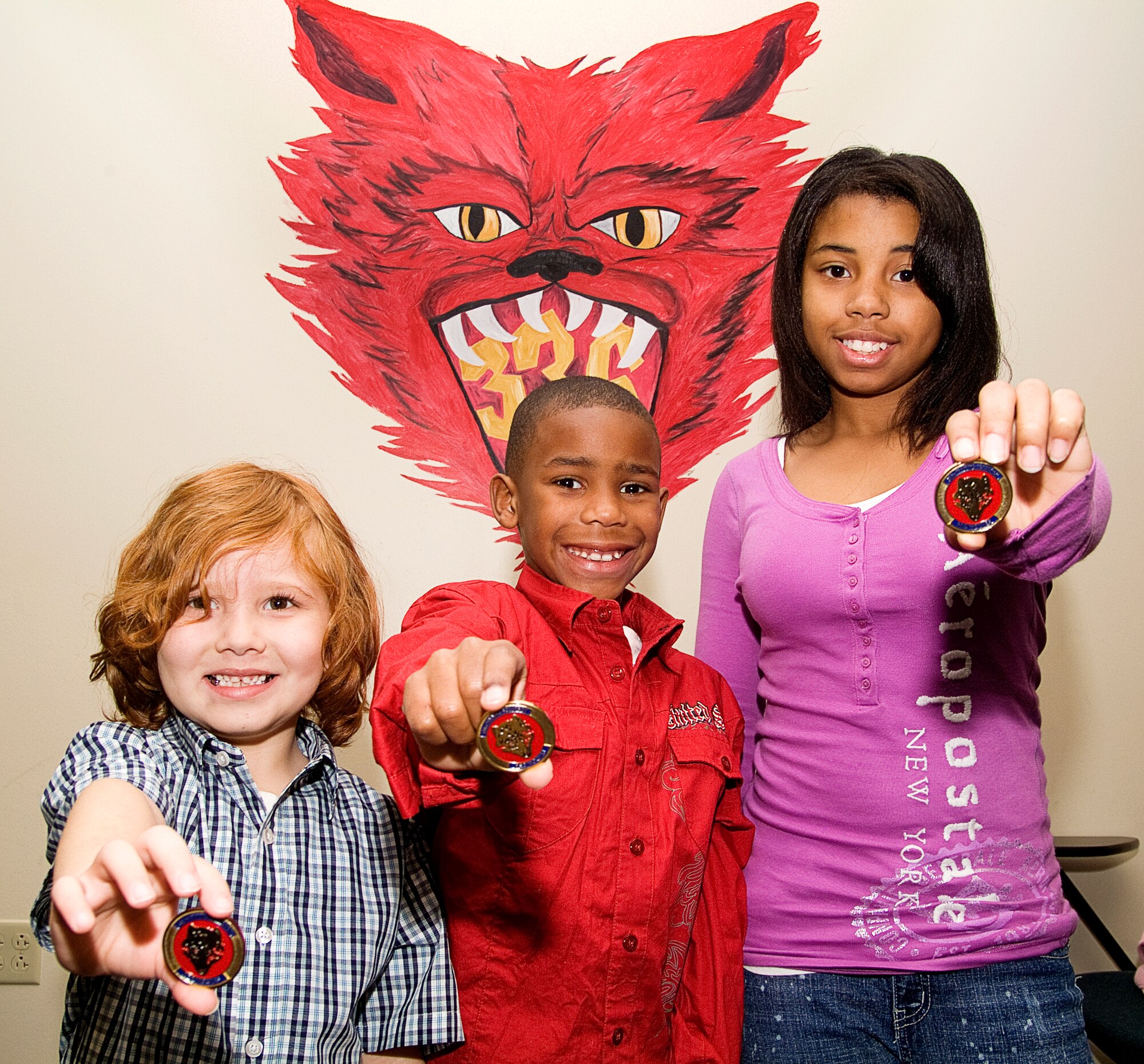 From left, Felix Rodriguez Jr. and A.J. and Audrey Simmons display coins they received during the 336th Training Squadron’s commander’s call Monday. The unit’s Key Spouses arranged for the children of squadron members who deployed in 2010 to receive Little Heroes certificates for supporting their parents. Felix, 5, is the son of Tech. Sgt. Felix and Gina Rodriguez. A.J., 7, and Audrey, 12, are the children of Tech. Sgt. Joanne and Tony Simmons.  (U.S. Air Force photo by Herb Welch)