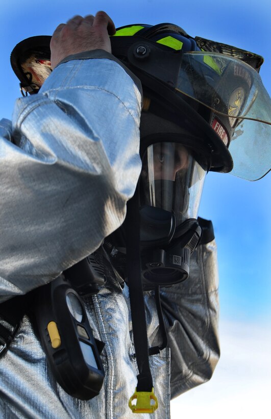 Airman Robert Marriot, 28th Civil Engineer Squadron firefighter, gears up before indoor fire training at Ellsworth Air Force Base, S.D., Jan. 27.  The fire department trained with Col. Trent Edwards, 28th Mission Support Group commander, to put out indoor fires. (U.S. Air Force photo/Senior Airman Anthony Sanchelli)
