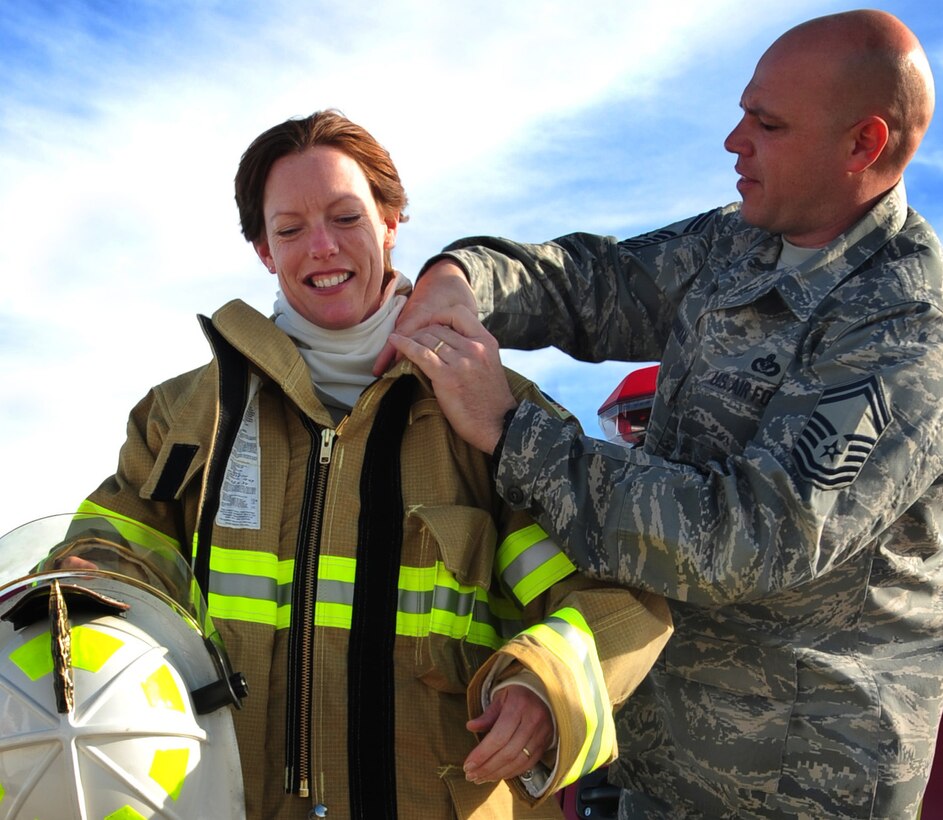 (Left to right) Lt. Col. Launa Bellucci, 28th Mission Support Group deputy commander, dons firefighter gear with the assistance of Senior Master Sgt. Robert Herman, 28th Civil Engineer Squadron deputy fire chief, at Ellsworth Air Force Base, S.D., Jan. 27.  The fire department trained with Col. Trent Edwards, 28th Mission Support Group commander and Lt. Col. Launa Bellucci, 28th MSG deputy commander, to put out indoor fires. (U.S. Air Force photo/Senior Airman Anthony Sanchelli)
