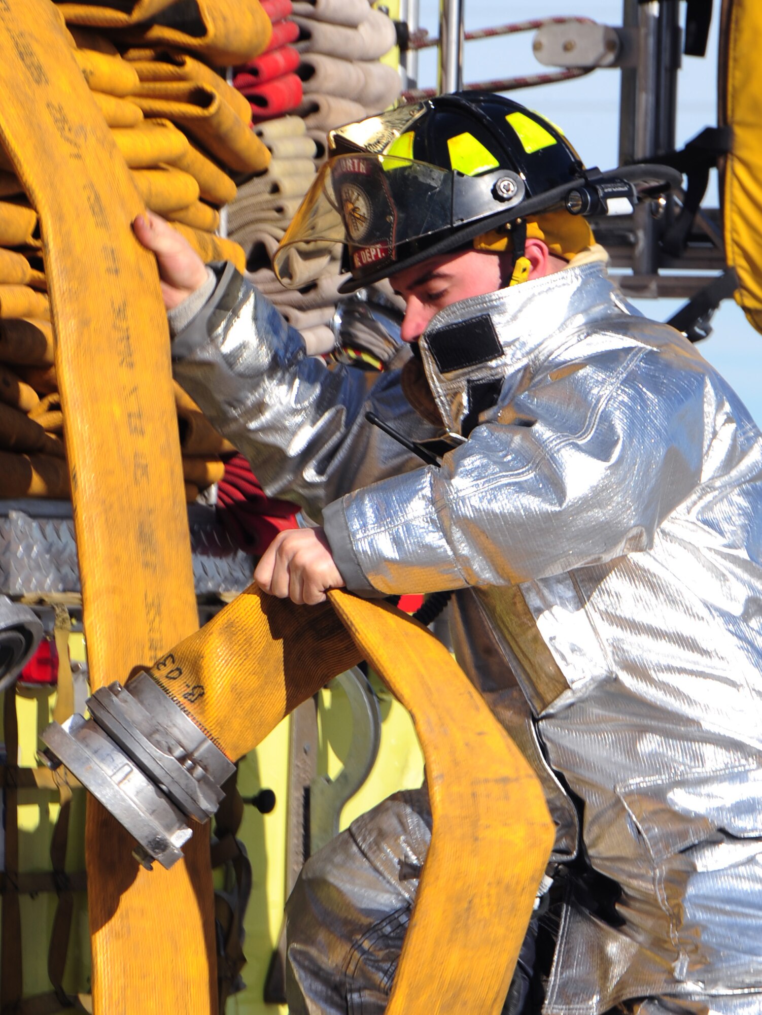 Airman 1st Class Zechariah Engwall, 28th Civil Engineer Squadron firefighter, uncoils a fire truck’s water hose at Ellsworth Air Force Base, S.D., Jan. 27.  The fire department trained with Col. Trent Edwards, 28th Mission Support Group commander, to put out indoor fires. (U.S. Air Force photo/Senior Airman Anthony Sanchelli)
