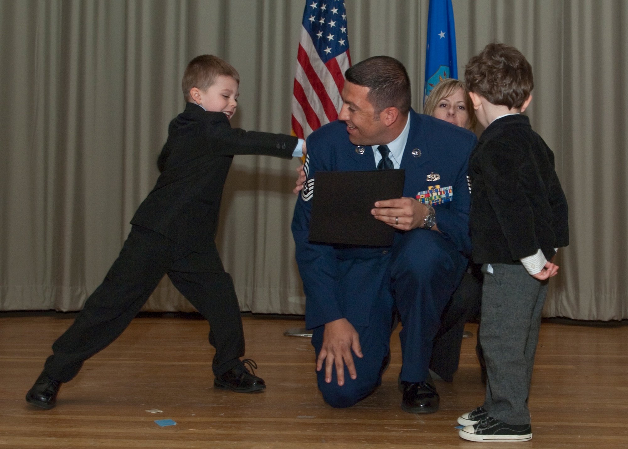 Tech. Sgt. Michael S. Fountain receives a “love tap” from his son after being promoted to master sergeant. Friends, family and colleagues joined 33 Airmen as they earned new ranks in the Base Theater, Jan. 31 during Team Edwards' Monthly Promotion Ceremony. (Air Force photo by Michael Yncera)