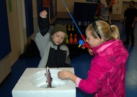 MINOT AIR FORCE BASE, N.D. -- Brandyn and Caitlynne Hulett, children of Staff Sgt. Justin Hulett, 5th Logistics Readiness Squadron fuels distribution supervisor, participate in a fishing game during the Winter Carnival at the youth center here Jan. 28. Events like this are provided for Airmen and their families to maintain the well-being of military families. (Courtesy photo)