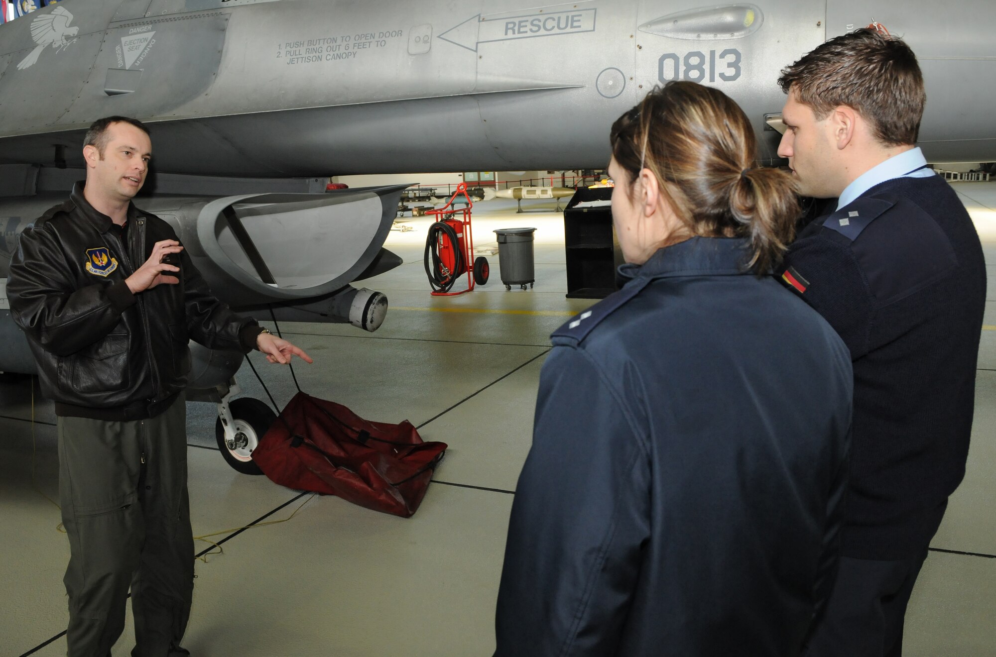 SPANGDAHLEM AIR BASE, Germany – Maj. Shaun Bellamy, 52nd Fighter Wing executive officer, talks with German air force weapons controllers about the F-16 Fighting Falcon and how he communicates with 606th Air Control Squadron weapons directors during flights. Eight German air force members visited the 606th ACS for briefings and interactive opportunities as they train to become combat ready aircraft controllers at the Tactical Air Command and Control Training Section in Meßstetten, Germany. (U.S. Air Force photo/Airman 1st Class Matthew B. Fredericks)