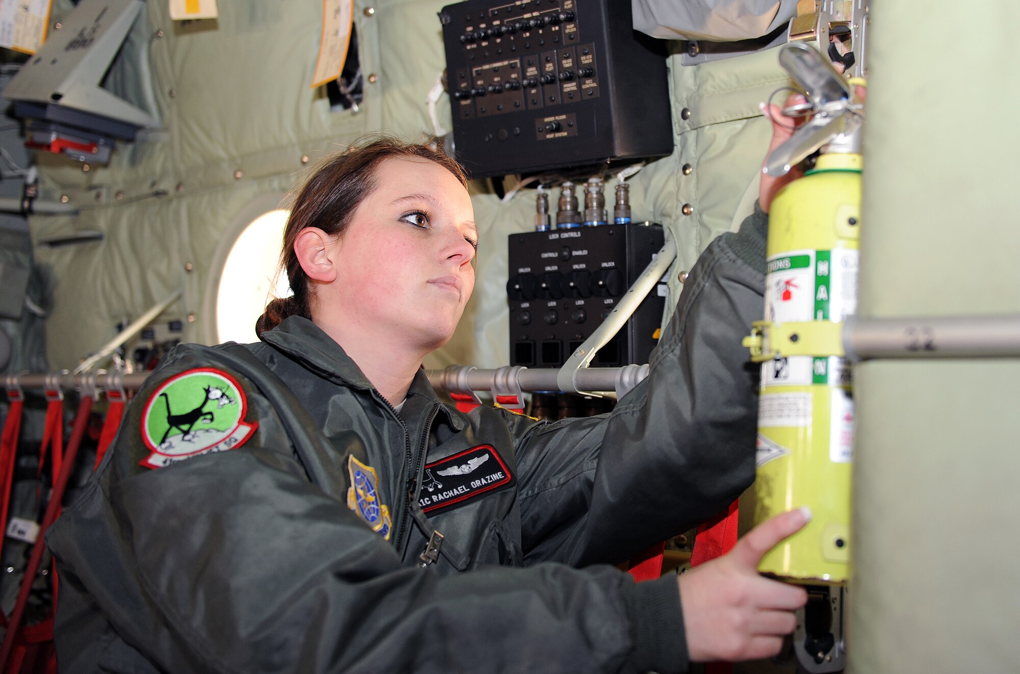 Airman 1st Class Rachel Orazine, a 41st Airlift Squadron loadmaster, checks a fire extinguisher as part of a preflight check on a C-130 Jan. 25, 2011, on the flightline at Little Rock Air Force Base, Ark. Airman Orazine received the Chief’s Group Sharp Troop Award for finishing her first Career Development Course test and obtaining her second set of books while deployed. She was also  the youngest squadron Airman selected for Air Mobility Command Mobility Air Forces Exercises. (Air Force photo by Airman 1st Class Ellora Stewart)