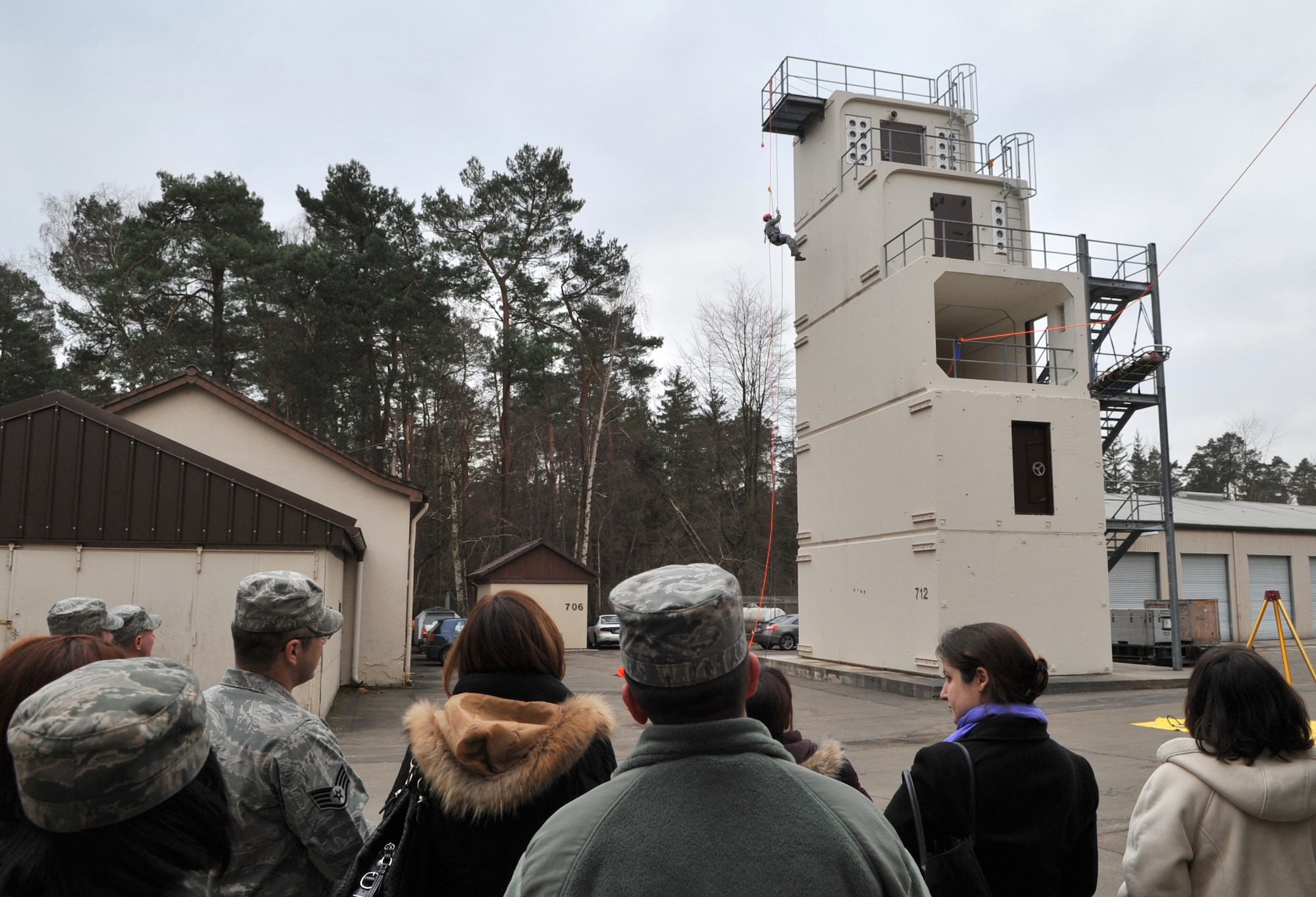 RAMSTEIN AIR BASE, Germany - Airmen from the 435th Construction and Training Squadron demonstrate their repelling capabilities down a tower for Betty Welsh, wife of Gen. Mark A. Welsh III, U.S. Air Forces in Europe commander, and a group of commander and command chief spouses during an immersion, Jan. 28, 2011. Also on the tour were Laura Shapland, wife of 435th Air Ground Operations Wing Commander Col. John Shapland; Mary Williamson, wife of USAFE Command Chief Master Sgt. Dave Williamson; and Margie Stippel, wife of 435th AGOW Command Chief Master Sgt. Mitch Stippel. (U.S. Air Force photo by Senior Airman Caleb Pierce)