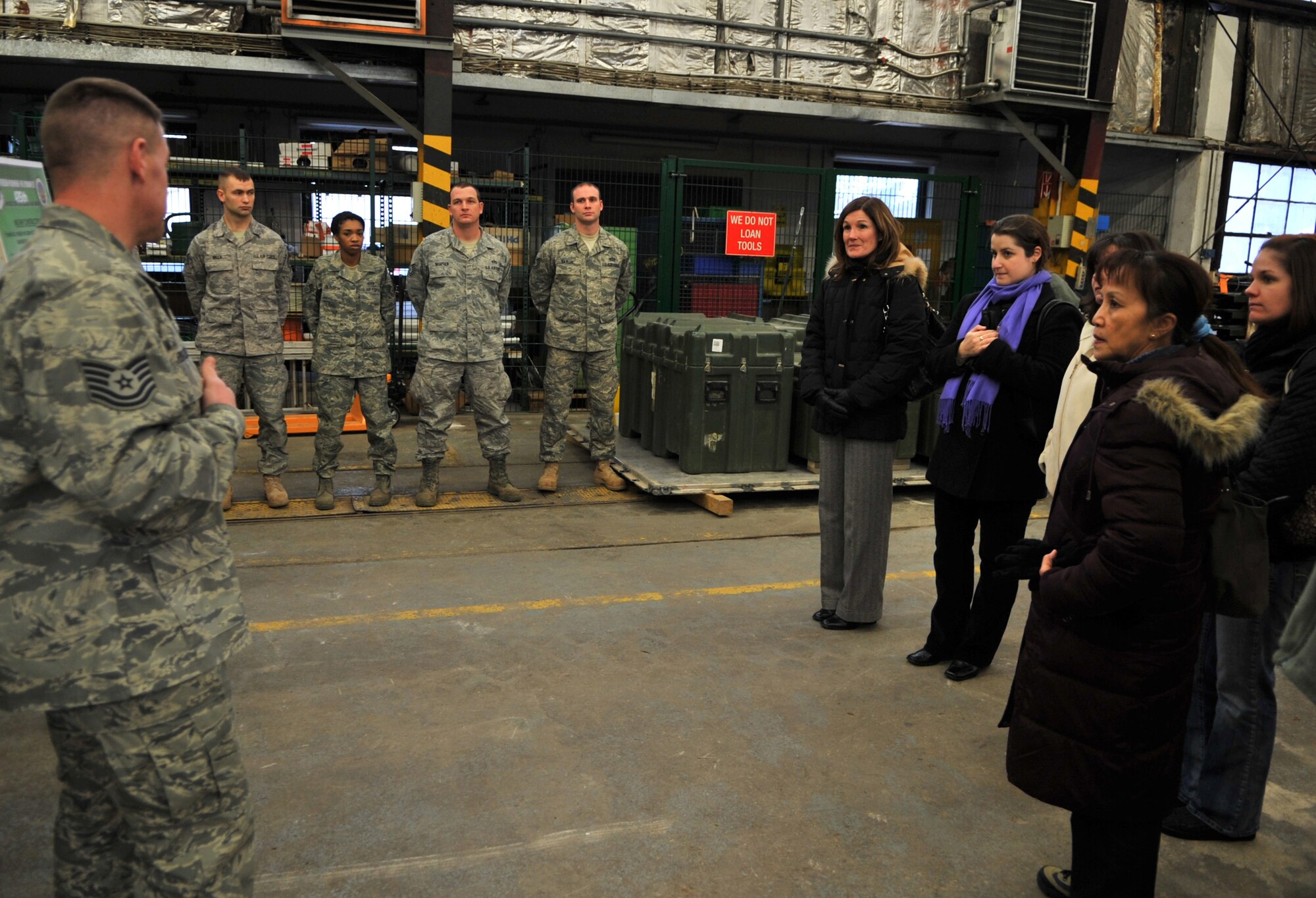 RAMSTEIN AIR BASE, Germany - Tech Sgt. Thomas Riggsbee, 435th Construction and Training Squadron NCO in charge of structures, briefs Betty Welsh (center), wife of Gen. Mark A. Welsh III, U.S. Air Forces in Europe commander, and a group of commander and command chief spouses during an immersion, Jan. 28, 2011. Also on the tour were Laura Shapland, wife of 435th Air Ground Operations Wing Commander Col. John Shapland; Mary Williamson, wife of USAFE Command Chief Master Sgt. Dave Williamson; and Margie Stippel, wife of 435th AGOW Command Chief Master Sgt. Mitch Stippel. (U.S. Air Force photo by Senior Airman Caleb Pierce)