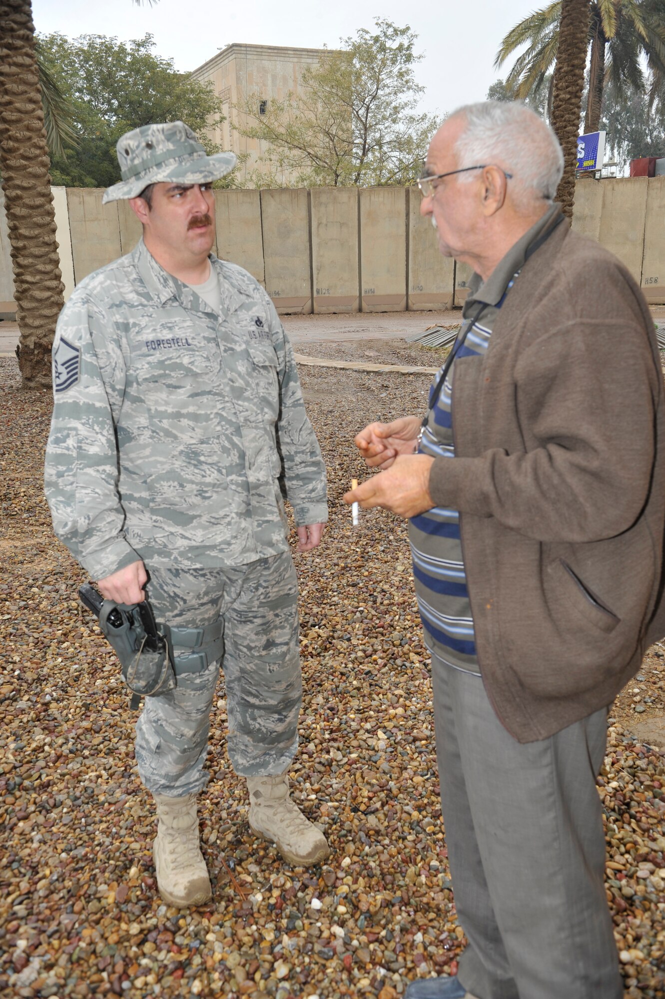 Master Sgt. Erik Forestell, facility engineer team NCO in charge, 467 Air Expeditionary Group, discusses construction plans with an Iraqi contractor to ensure the work is up to code at Forward Operating Base Union III, International Zone, Baghdad, Iraq, Jan. 29, 2011. (Air Force photo by Senior Master Sgt. Larry Schneck/Released)