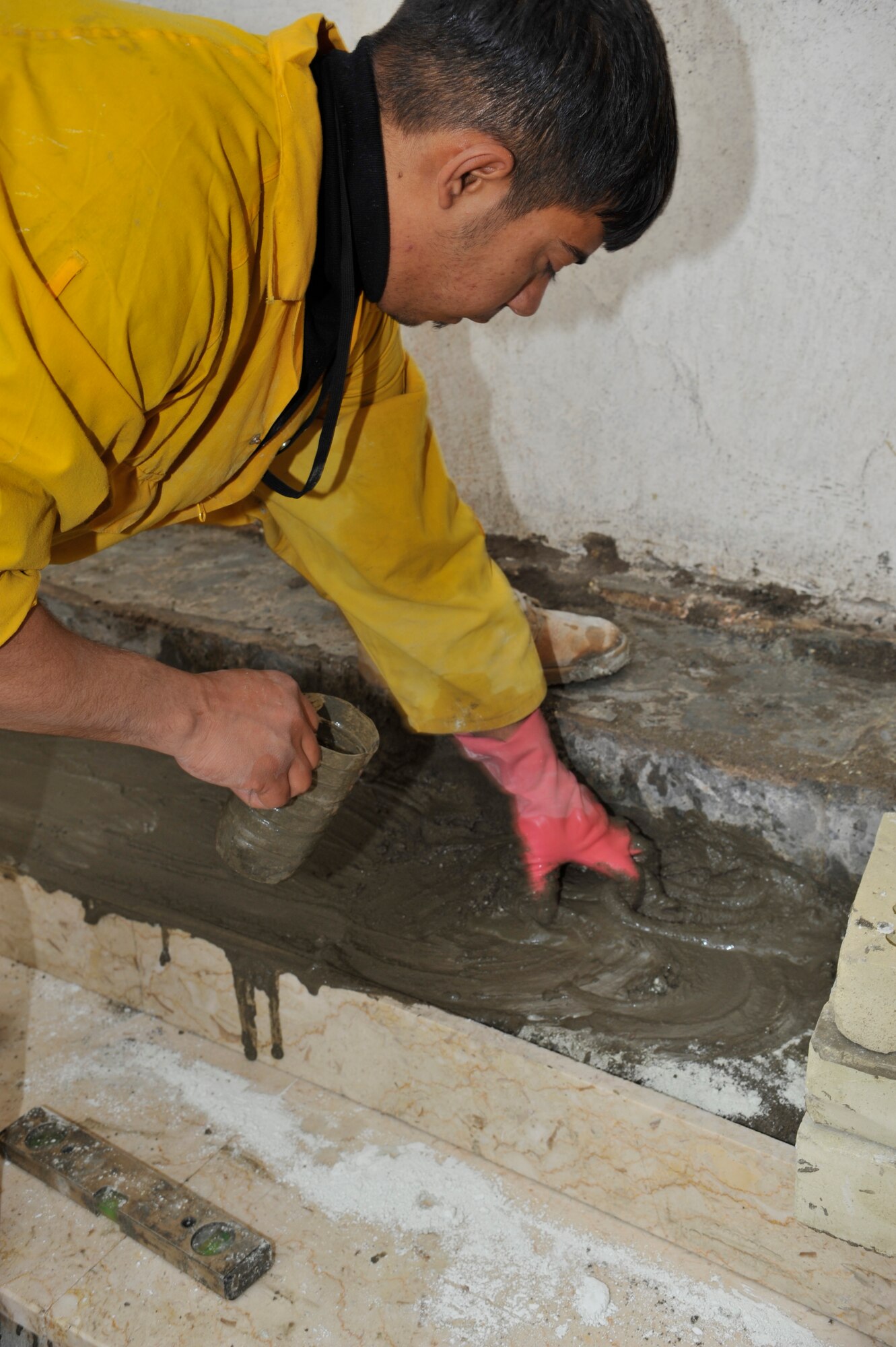 An Iraqi construction worker lays concrete for a step at a facility on Forward Operating Base Union III, International Zone, Baghdad, Iraq, Jan. 29 2010. (Air Force photo by Senior Master Sgt. Larry Schneck/Released)