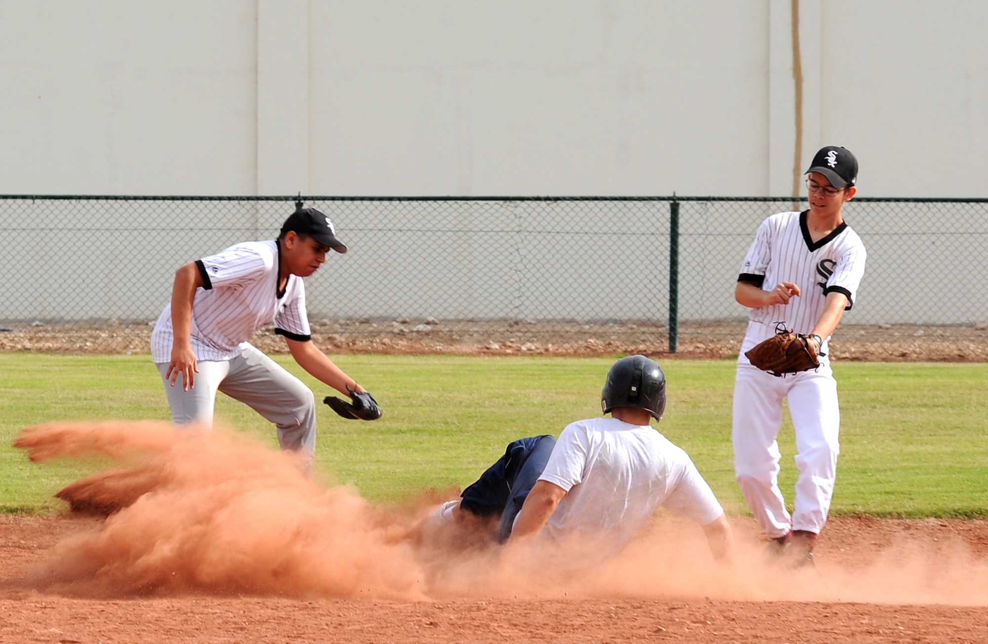 Senior Airman Tim Carlson, 379th Expeditionary Security Forces Squadron, slides into second base during a friendly baseball game, Jan. 29. (U.S. Air Force photo/ Staff Sgt. Liliana Moreno)