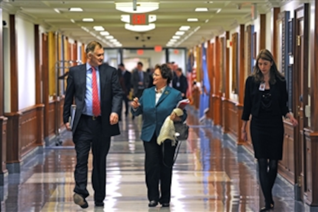 Deputy Secretary of Defense William J. Lynn III and British Permanent Under Secretary for Defense Ursula Brennan walk down the Pentagon's executive corridor transitioning from a meeting on defense procurement issues to one dealing with cyber security on Feb. 1, 2011.  