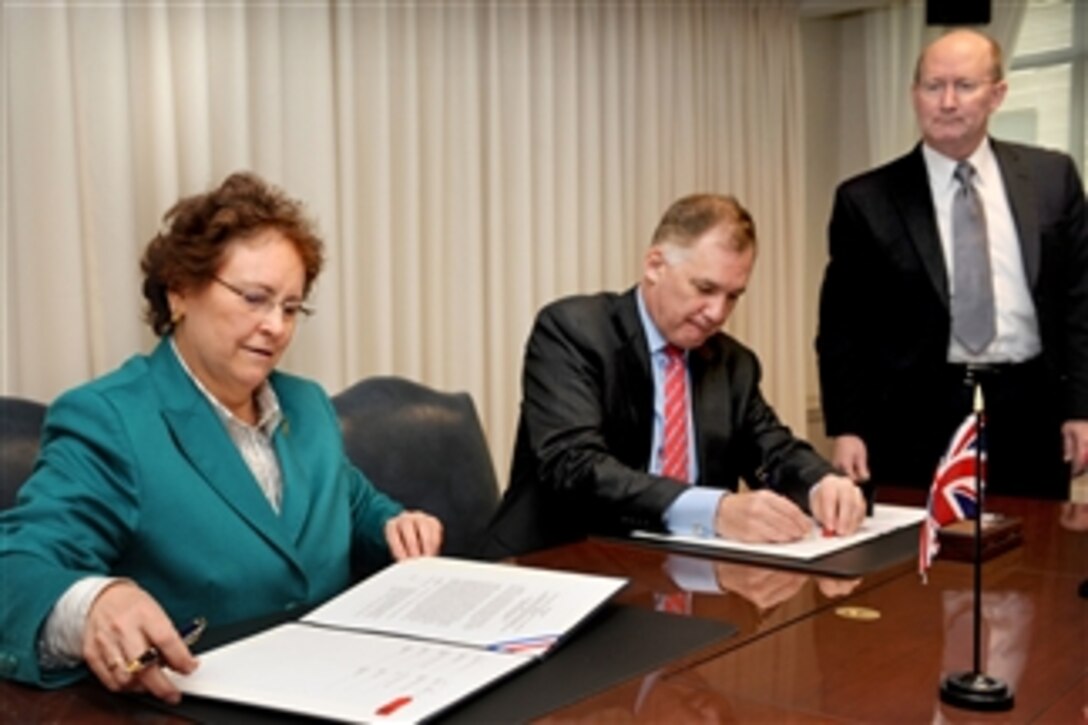 British Permanent Under Secretary for Defense Ursula Brennan and Deputy Secretary of Defense William J. Lynn III sign an agreement on the U.S. - U.K. Counter Improvised Explosive Device program at the conclusion of a meeting of the Bilateral Defense Acquisition Committee in the Pentagon on Feb. 1, 2011.  The Director for International Negotiations Frank Kenlon (right) looks on.  