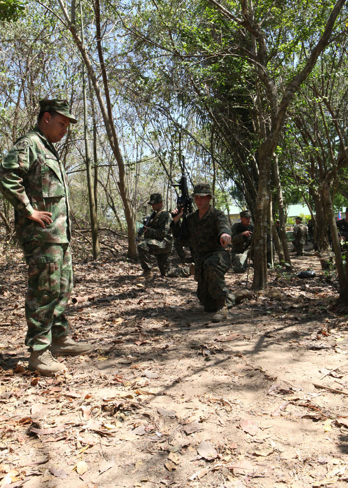 Colombian Marine Sgt. 2nd class Luis J. Rodriguez, Colombia's explosive ordnance disposal (EOD) team, instructs U.S. Marine Sgt. Justin Schmicker, point man, from Security Cooperation Task Force (SCTF), in tactical jungle warfare as they execute proper explosive detection on improvised explosive device (IED) lanes. SCTF is on a scheduled deployment in support of Amphibious Southern Partnership Station 2011 (A-SPS 11) to continue to build strong relationships with partner nations and regional services. (U.S. Marine Corps photo by Gunnery Sgt. Soukhi Forbes)