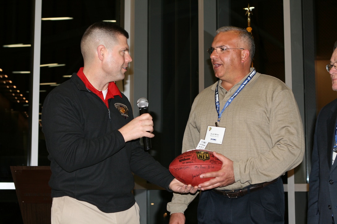 Major Brian Bilski presents a football autographed by wounded, ill and injured Marines to Scott Miller, of Republic Services, at a welcome dinner here at the Irving Convention Center tonight.   The signed football is a token of their appreciation for the support he will provide to the Marines during the time leading up to their attendance at Super Bowl XLV.   The 40 Marines and Marine veterans, supported by the United States Marine Corps Wounded Warrior Regiment, are from military treatment facilities and communities across the nation.