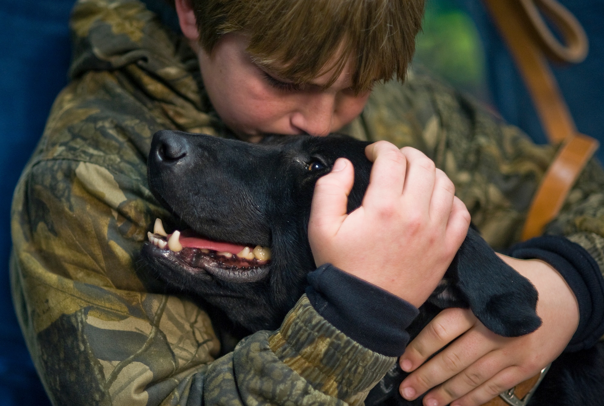 Brady Rusk, 12, hugs Eli, a bomb-sniffing military working dog, during a retirement and adoption ceremony Feb. 3, 2011, at Lackland Air Force Base, Texas. The Labrador retriever was assigned to Brady's older brother, Marine Pfc. Colton Rusk who was killed Dec. 5 in Afghanistan by Taliban sniper fire. Department of Defense officials granted the Rusk family permission to adopt Eli following his “retirement from the U.S. Marine Corps.” (U.S. Air Force photo/Tech. Sgt. Bennie J. Davis III) 
