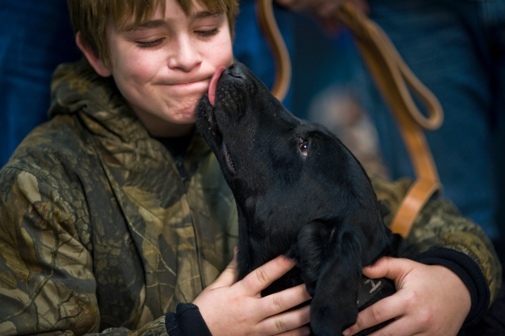 Brady Rusk, 12, gets somber kiss from Eli, a bomb-sniffing military working dog, during a retirement and adoption ceremony Feb. 3, 2011, at Lackland Air Force Base, Texas.  The Labrador retriever was assigned to Brady's older brother, Marine Pfc. Colton Rusk who was killed Dec. 5 in Afghanistan by Taliban sniper fire. Department of Defense officials granted the Rusk family permission to adopt Eli following his “retirement from the U.S. Marine Corps.” (U.S. Air Force photo/Tech. Sgt. Bennie J. Davis III)