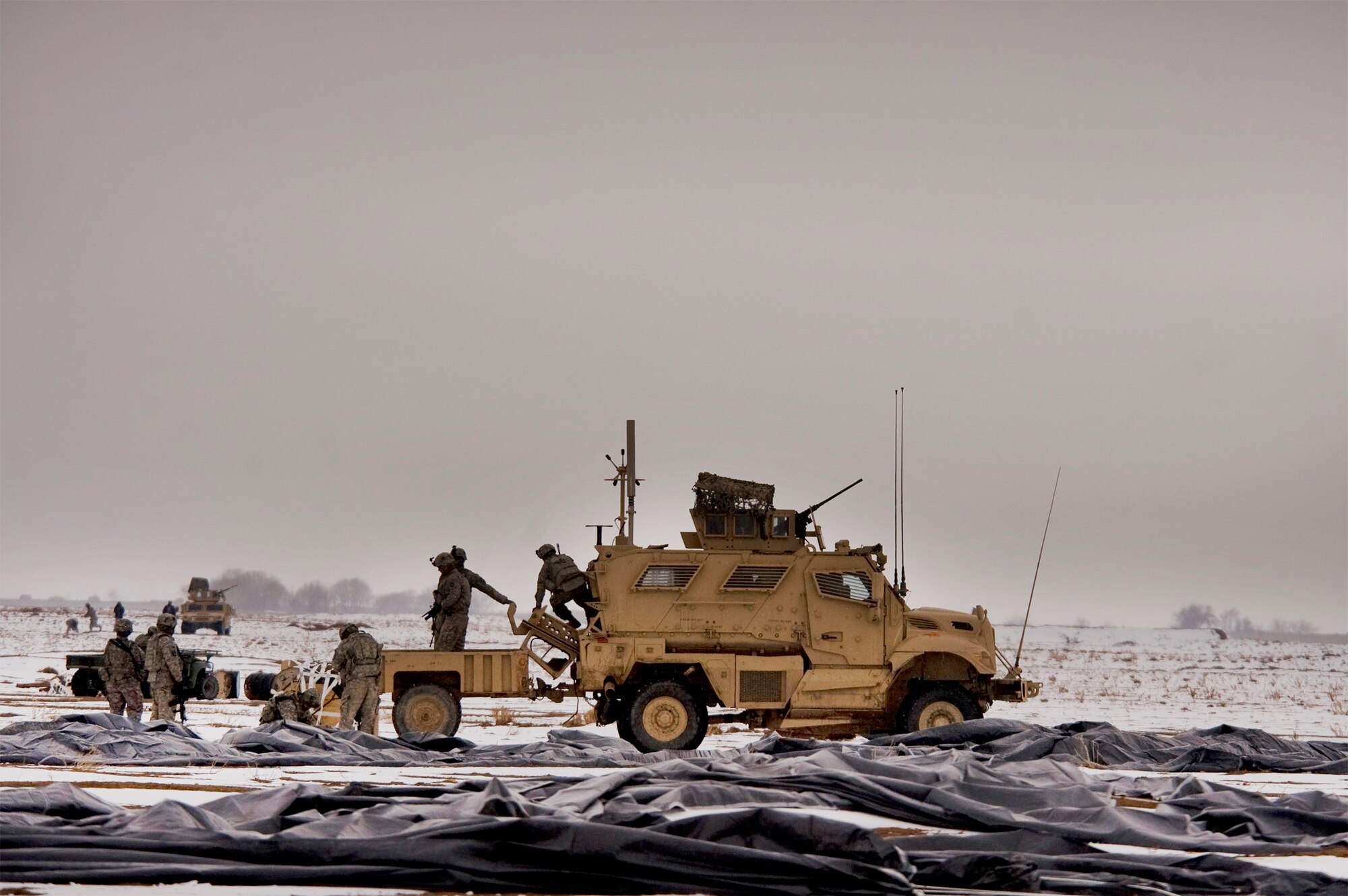 Soldiers from Task Force Currahee, 4th Brigade, 101st Airborne Division, recover bundles of fuel Jan. 29, 2011, that were air delivered to Forward Operating Base Waza K'wah, Afghanistan, via a C-17 Globemaster III. The fuel was delivered to help sustain members of Task Force Currahee, whose only means of resupply is through air delivery. (U.S. Air Force photo/Master Sgt. Adrian Cadiz)