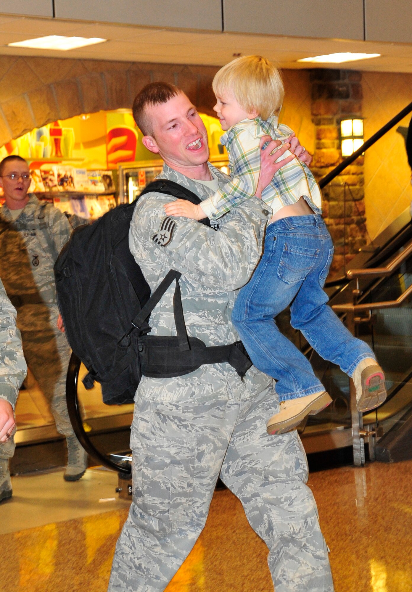 Staff Sgt. Robert Sasseen, 75th Security Forces Squadron, is greeted by his son, Carson, at the Salt Lake City International Airport on Jan. 31 as a group of 75th SFS personnel arrived to fanfare from friends and family members. (U.S. Air Force photo by Kim Cook)