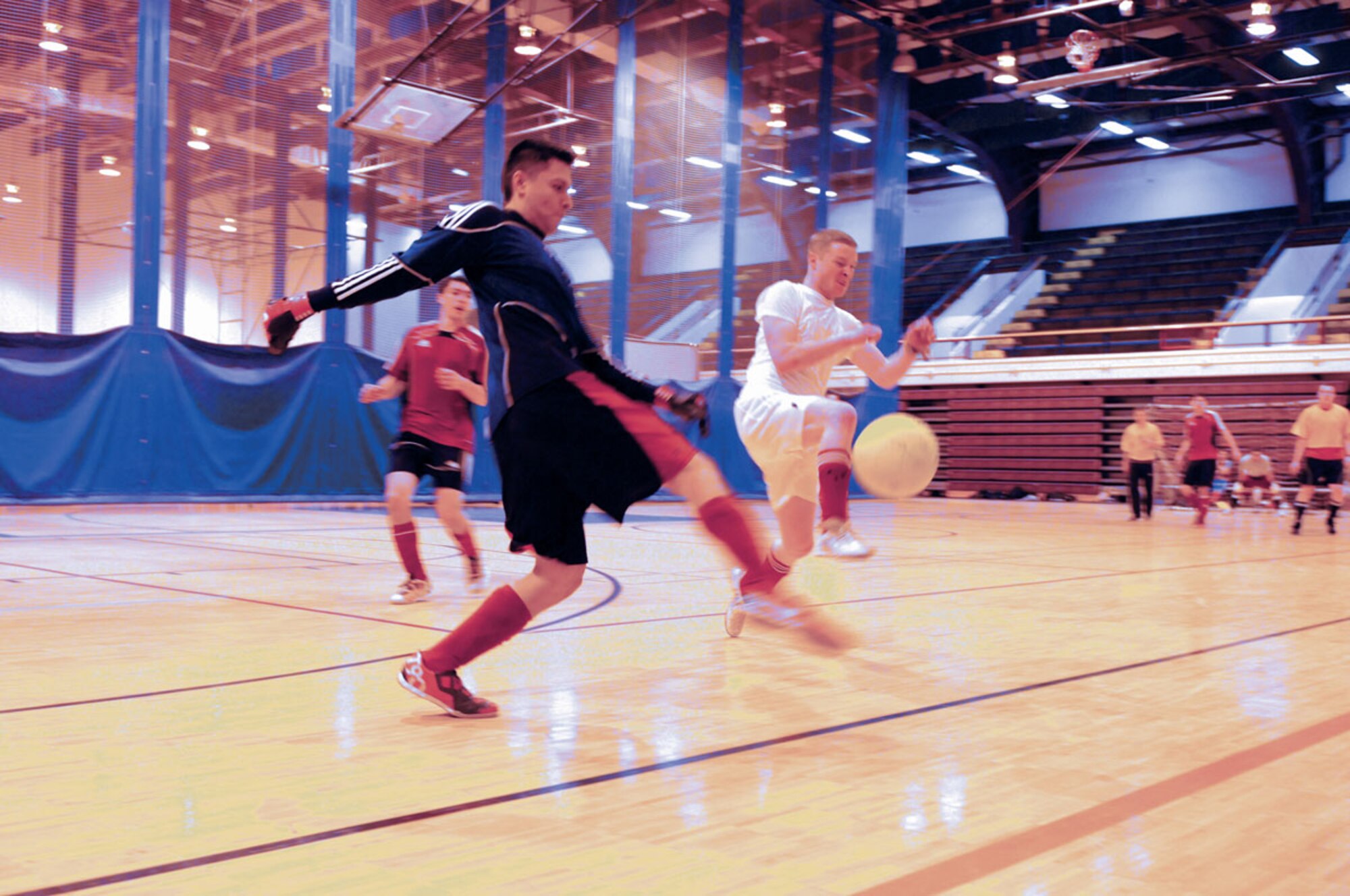 Lawrence Yazzie, 703rd AIrcraft Maintenance Squadron goalie, clears the ball away from Kyle Stetson, B Battery 2nd Battalion, 377th Parachute Field Artillery Regiment, during indoor soccer intramural action at the Buckner Physical Fitness Center Saturday.  (U.S. Air Force photo/Steve White)
