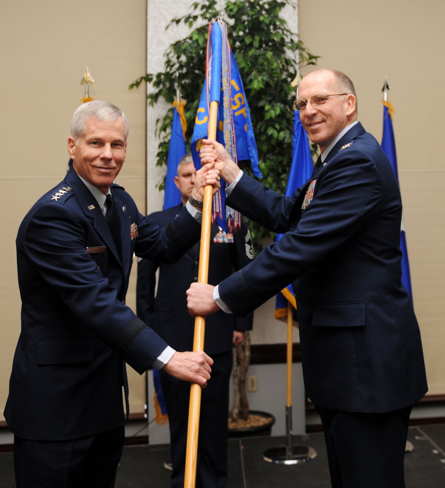 Col. Curtis O. Piontkowsky receives the Air Force Network Integration Center guidon from Gen. William Shelton as he assumed command Jan. 26. Colonel Piontkowsky previously was serving as the AFNIC's vice commander. His prior assignments include command of an Expeditionary Communications Squadron in Riyadh, Saudi Arabia;  Director of Communications in Kabul, Afghanistan; and 375th Communications Group Commander, also at Scott AFB. (U.S. Air Force photo/Airman 1st Class Divine Cox)    